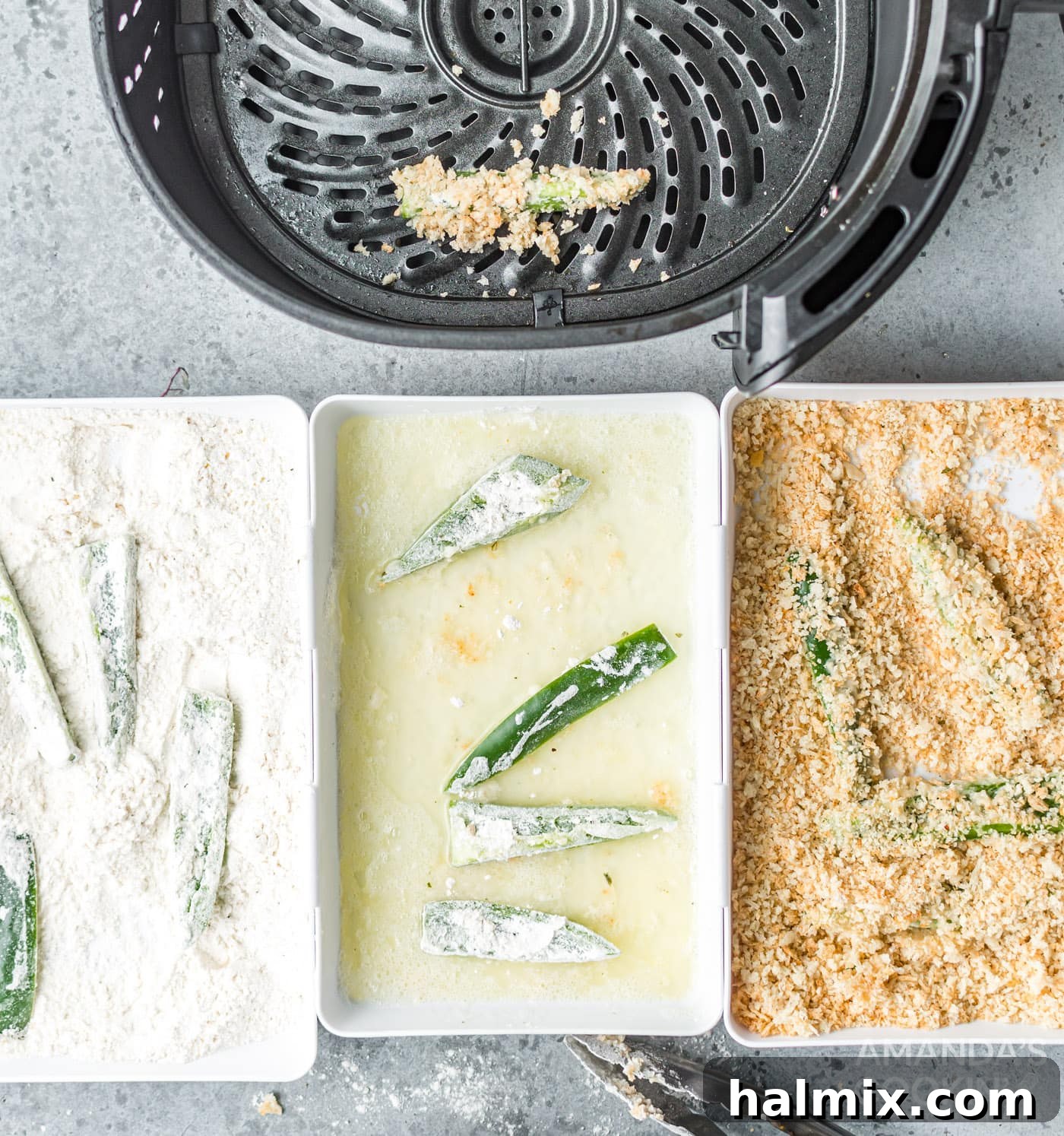 Jalapeno slices being coated in a dredging station with buttermilk, flour, egg whites, and panko