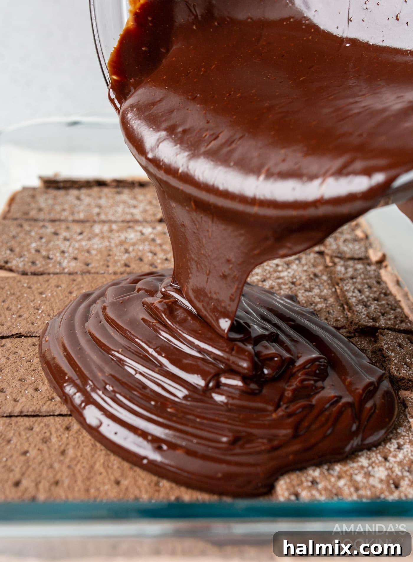 pouring ganache over chocolate graham crackers