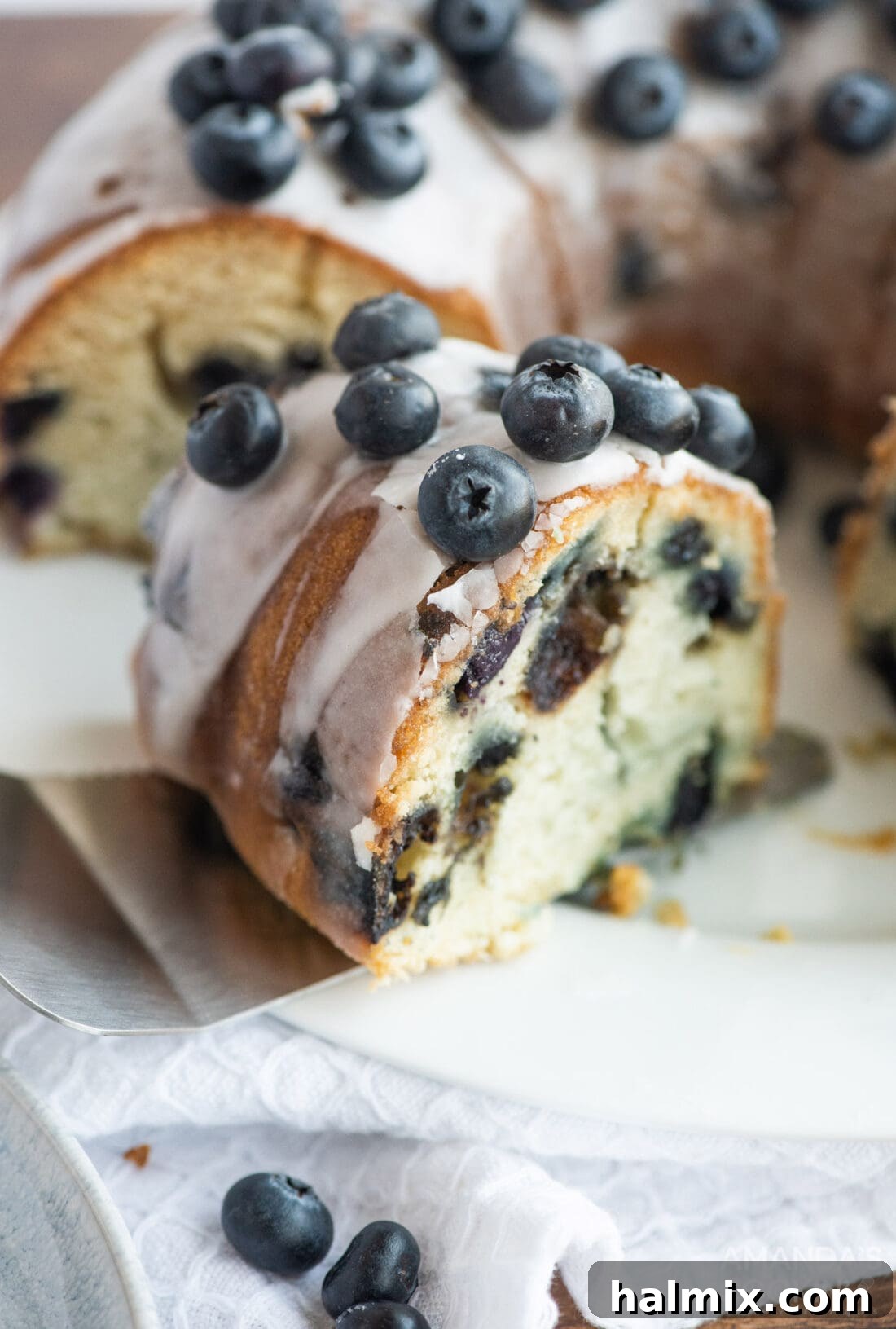removing a perfect slice of Blueberry Bundt Cake from a plate