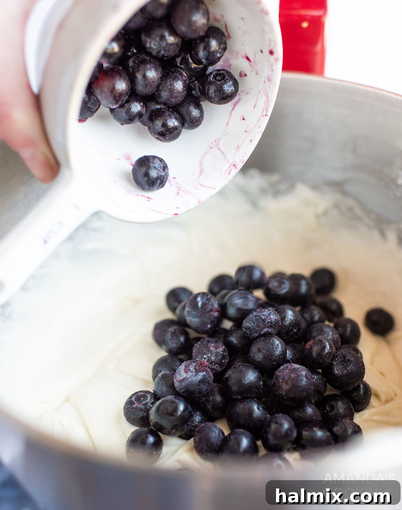adding fresh blueberries to cake batter, ready for mixing