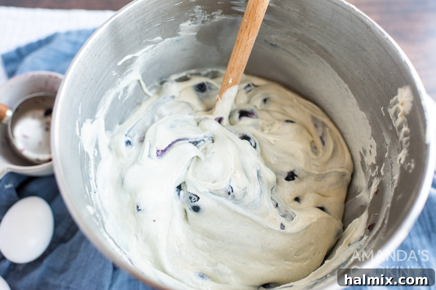 gently stirring blueberries into a creamy cake batter
