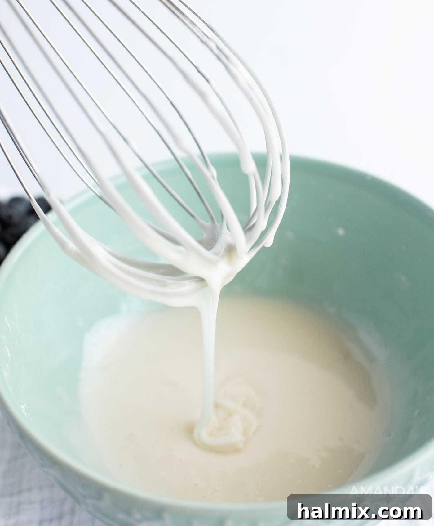 whisking ingredients to create a smooth, sweet glaze