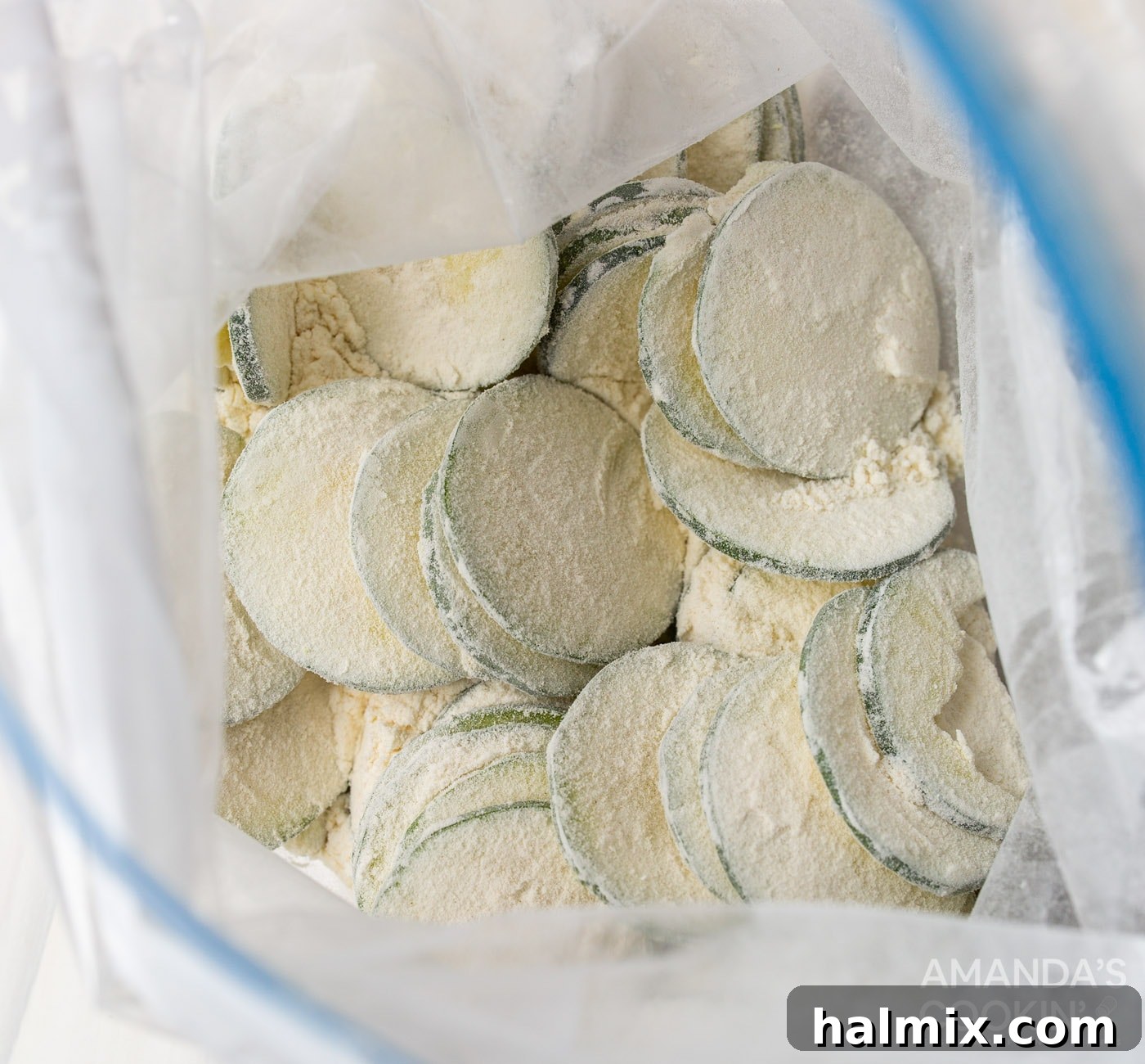 Zucchini slices being coated in flour inside a ziplock bag