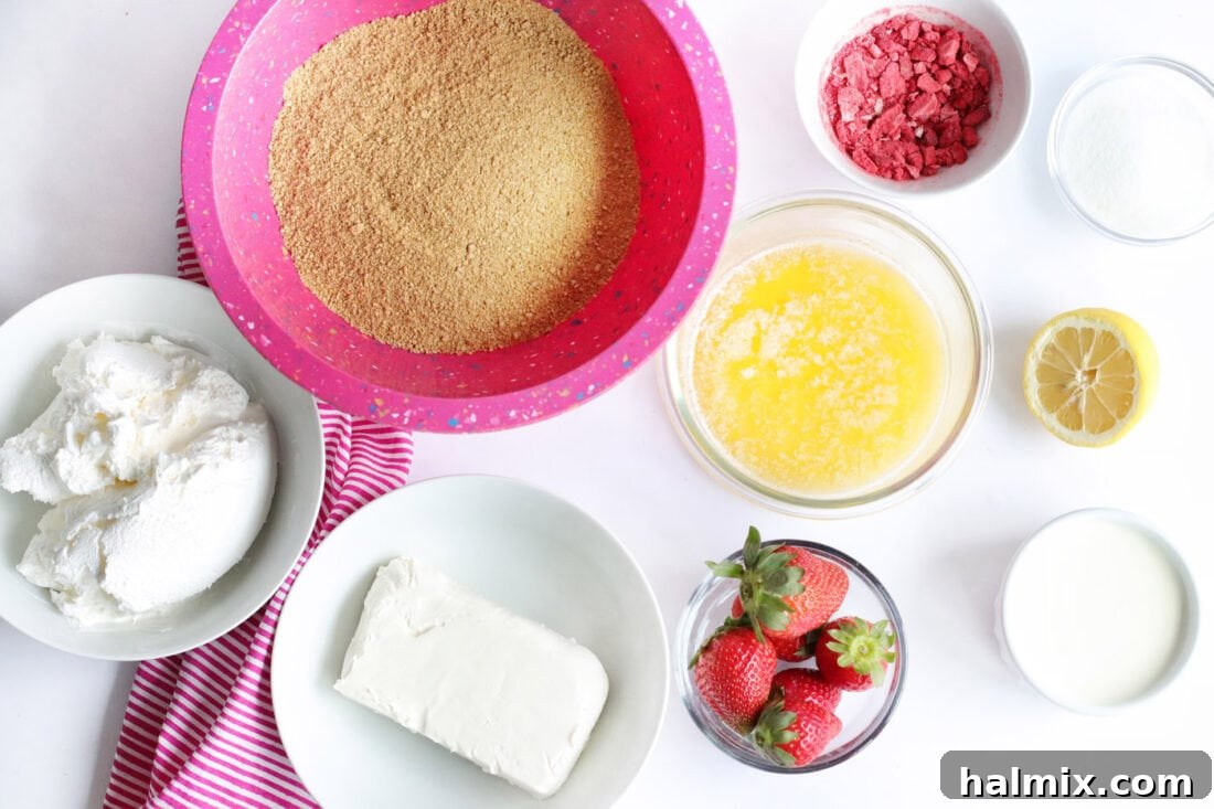 Ingredients laid out for No Bake Strawberry Cheesecake Bars, including strawberries, cream cheese, and graham crackers.