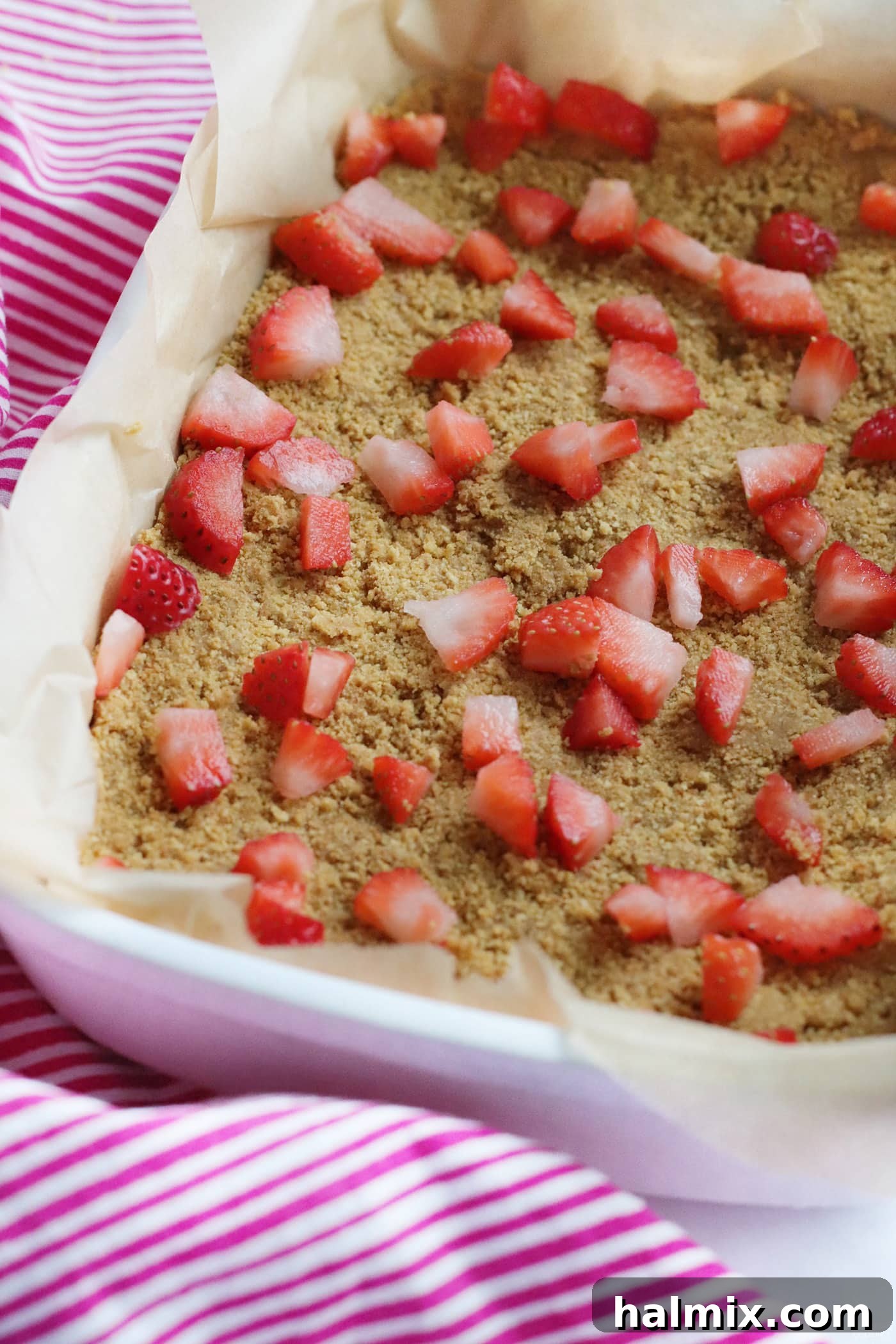 Chopped fresh strawberries spread in a single layer on top of a graham cracker crust.
