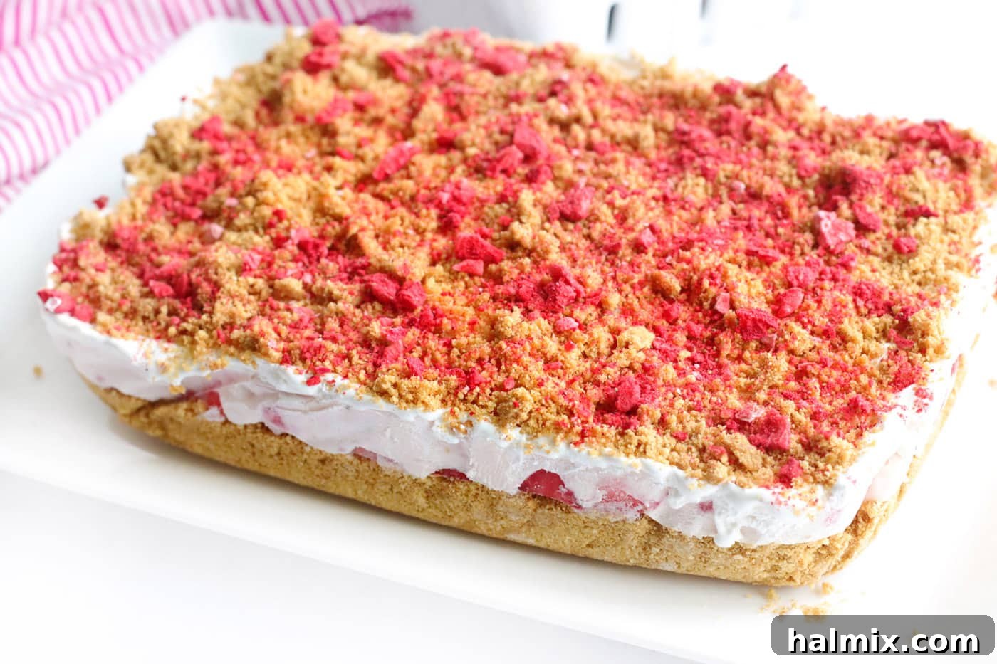 Finished no bake strawberry cheesecake bars with freeze-dried strawberry topping.