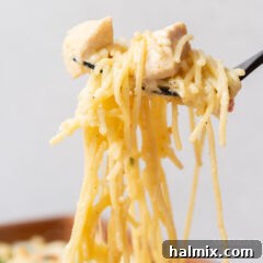 Chicken Spaghetti on a fork, showcasing its cheesy texture