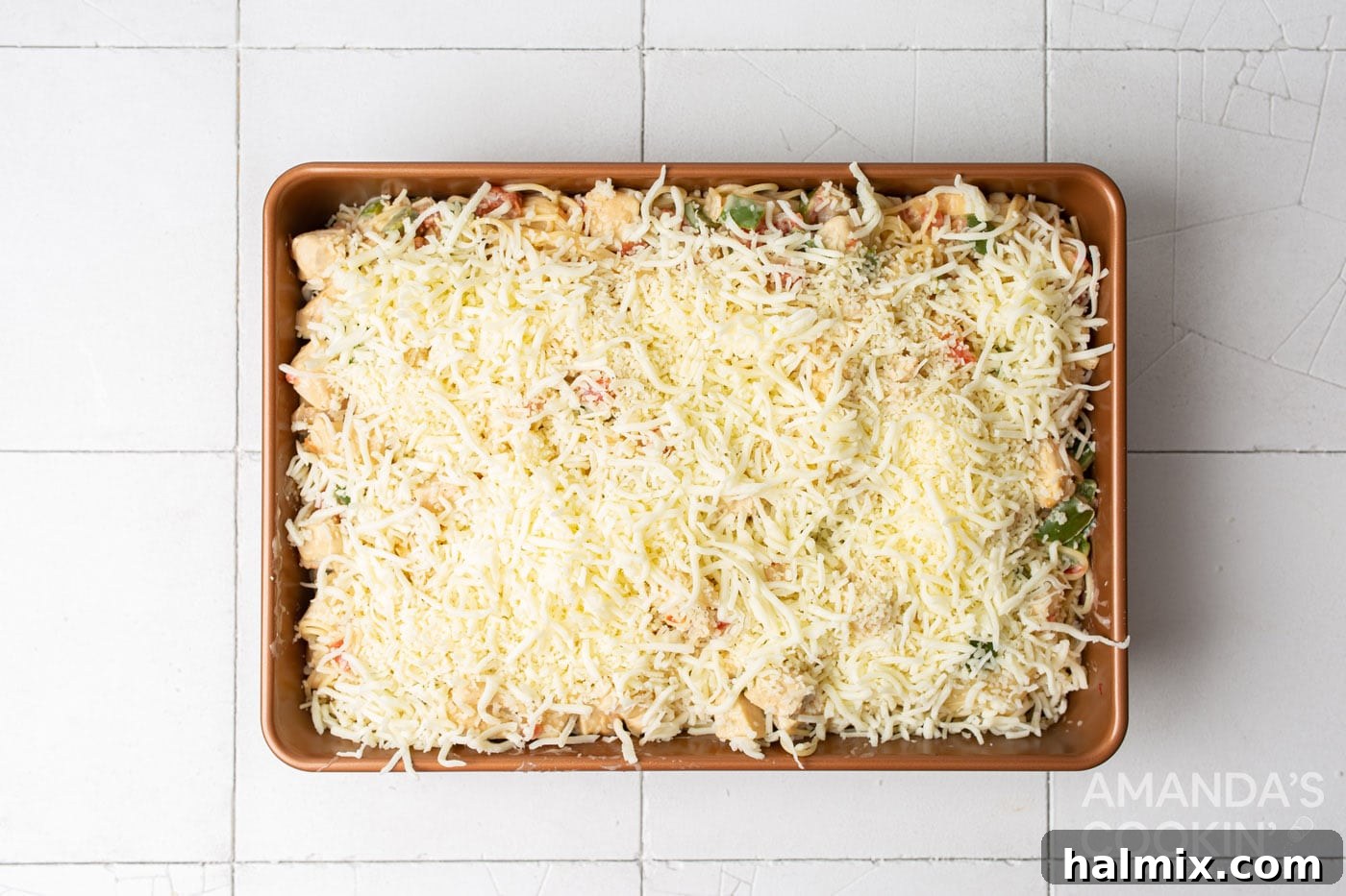 shredded cheese generously sprinkled on top of chicken spaghetti casserole before baking