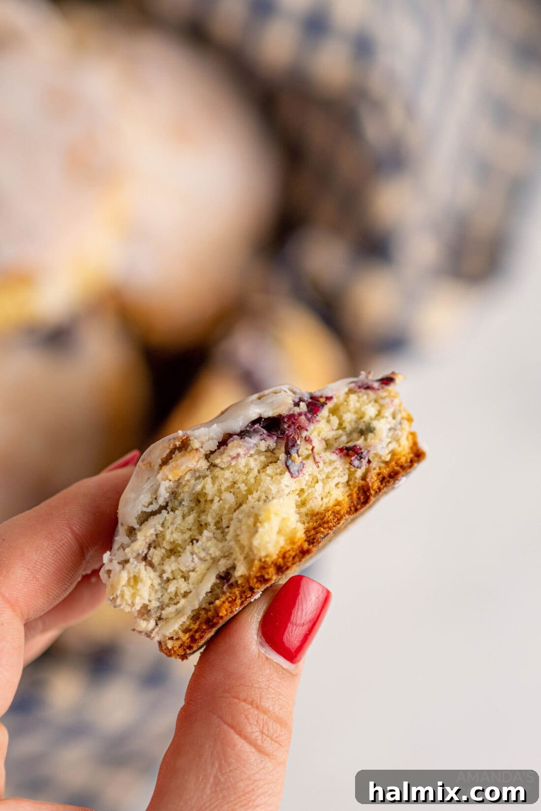 Divine Blackberry Scones 3 a hand holding a single glazed blackberry scone