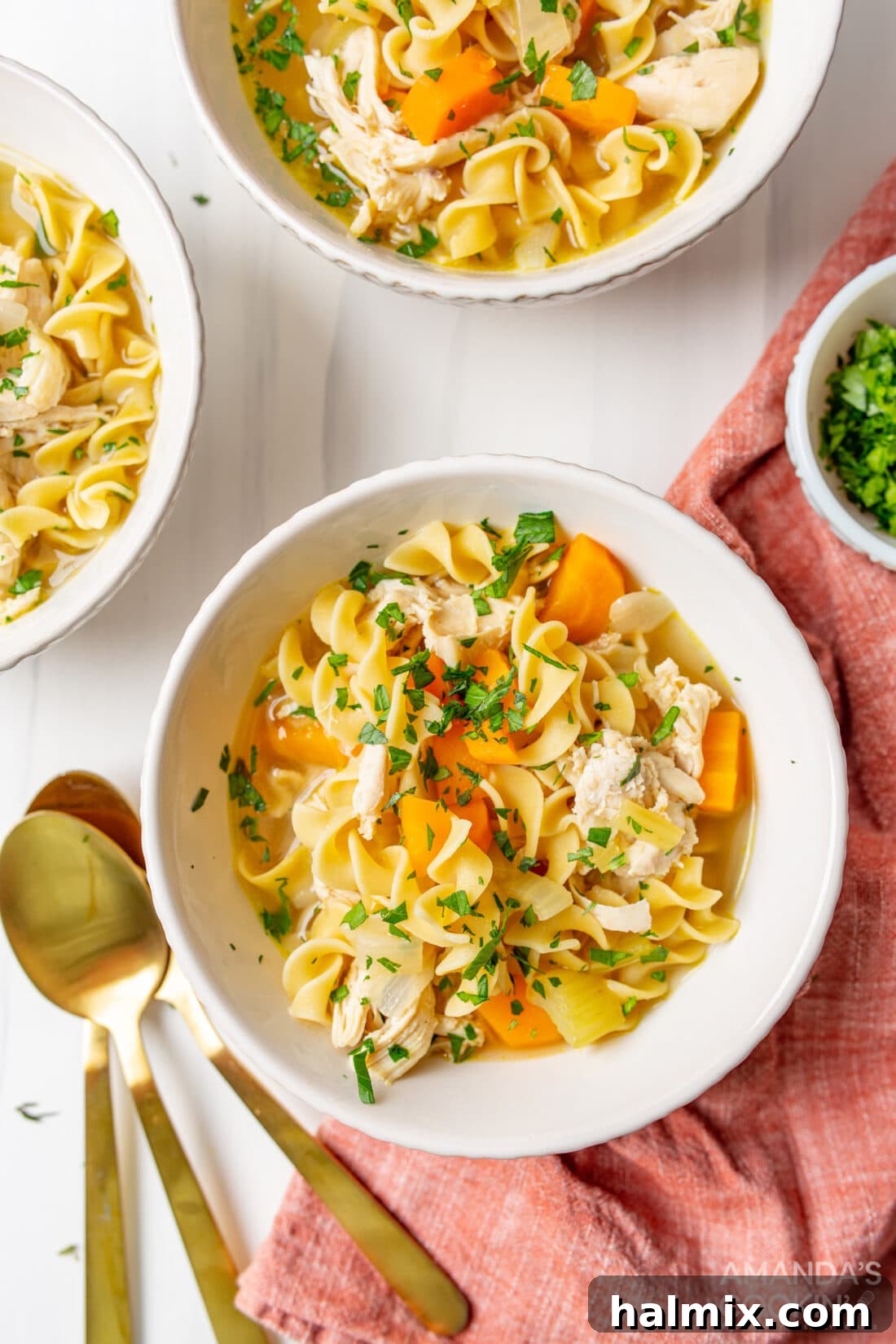 Golden Noodle Chicken Comfort 3 A steaming bowl of homemade chicken noodle soup on a rustic wooden table, garnished with fresh parsley.