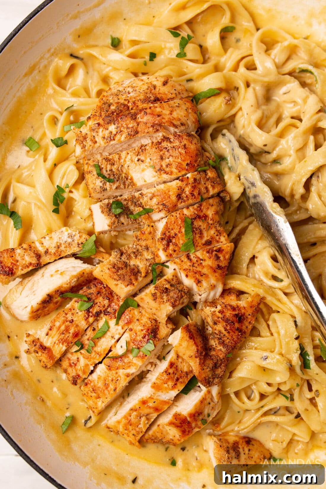 Chicken Alfredo with tongs