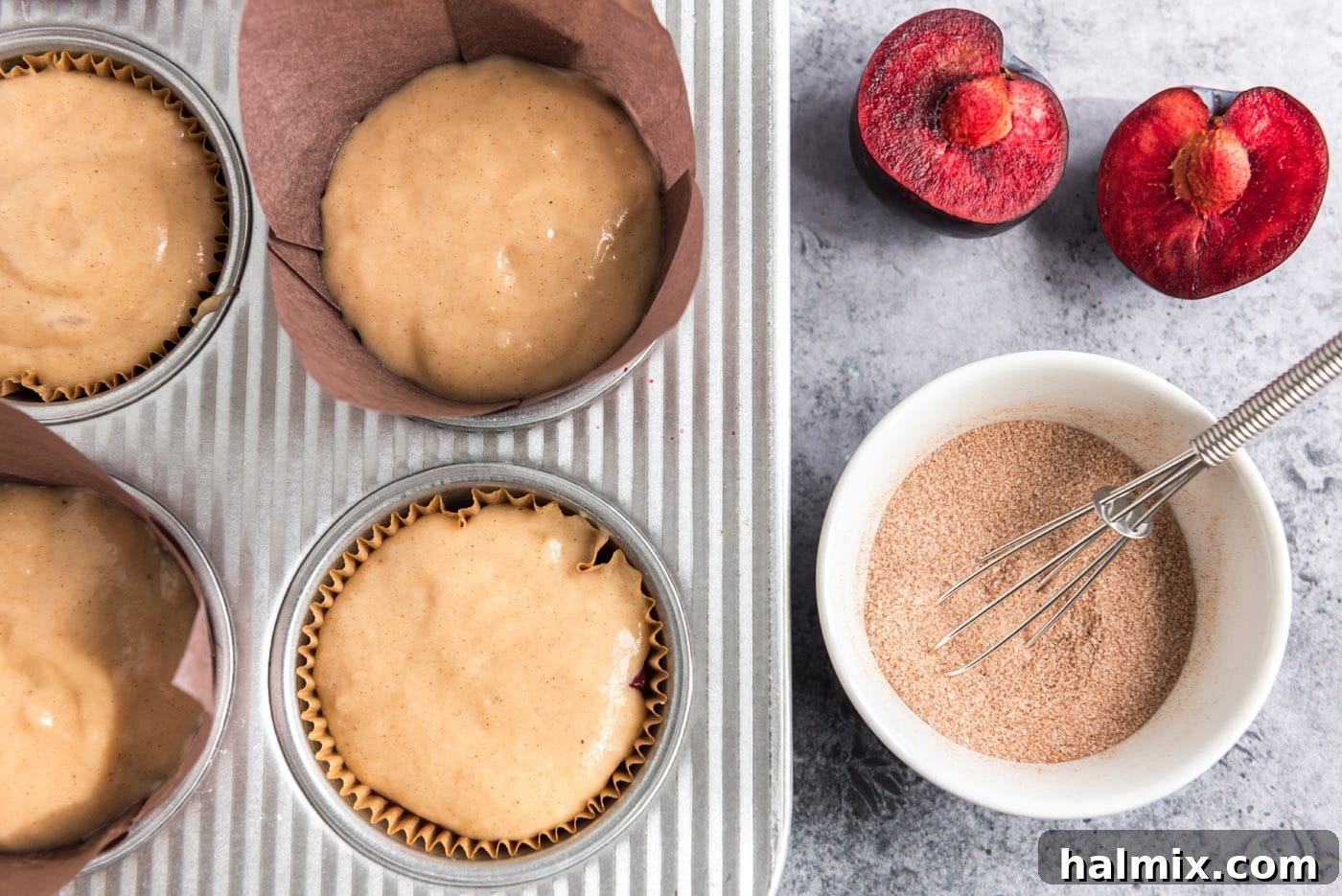 Golden Sugar Plum Muffins 15 A small bowl of cinnamon sugar mixture placed next to a muffin pan filled with plum muffin batter, ready for topping.
