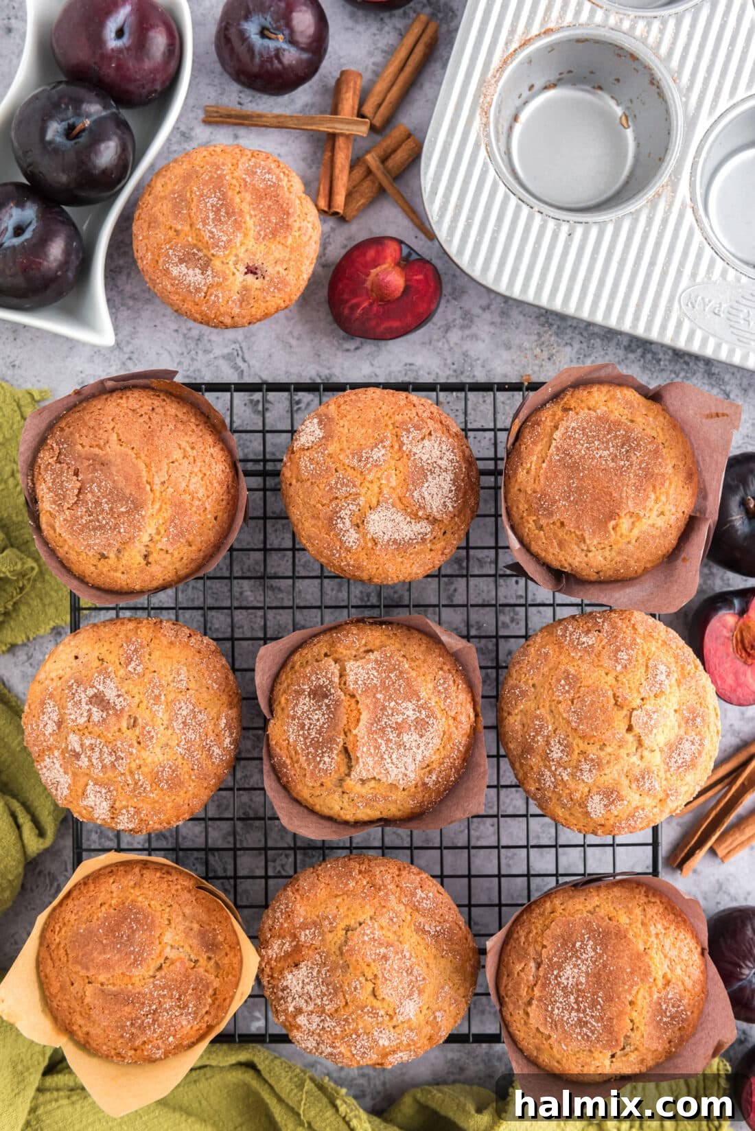 Golden Sugar Plum Muffins 18 Sugar Crusted Plum Muffins resting on a wire rack, cooling down after baking.