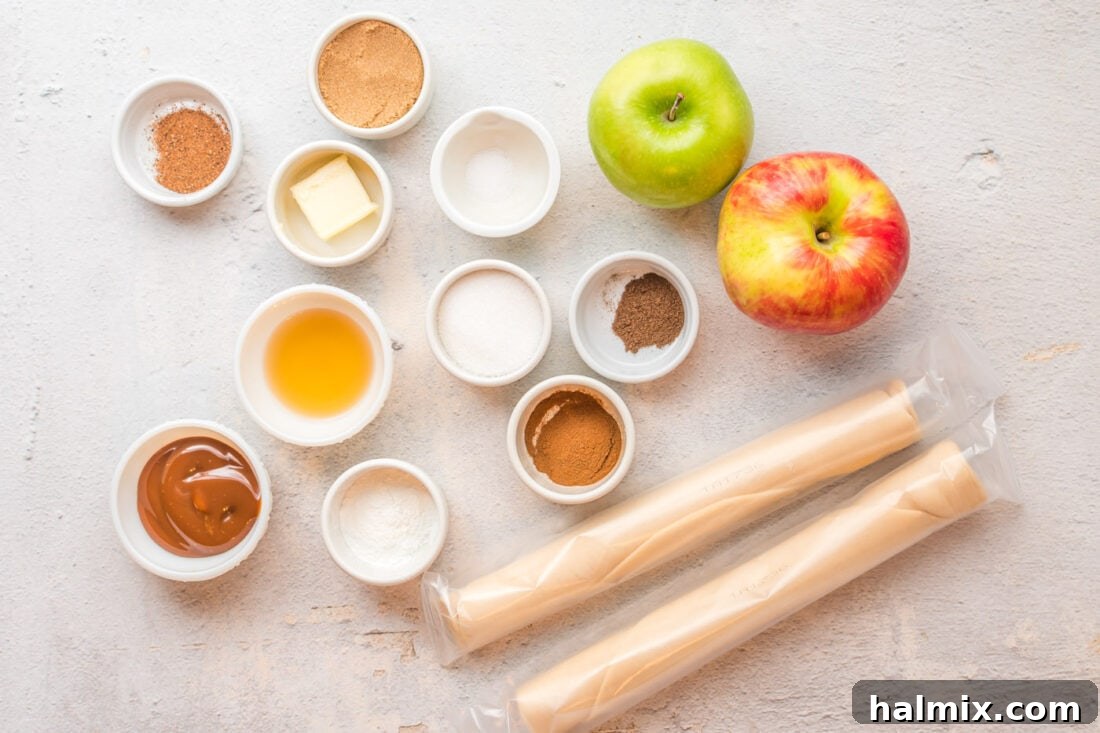 A beautiful display of fresh ingredients for apple hand pies, including vibrant apples, aromatic spices, creamy butter, and ready-to-use pie crust.
