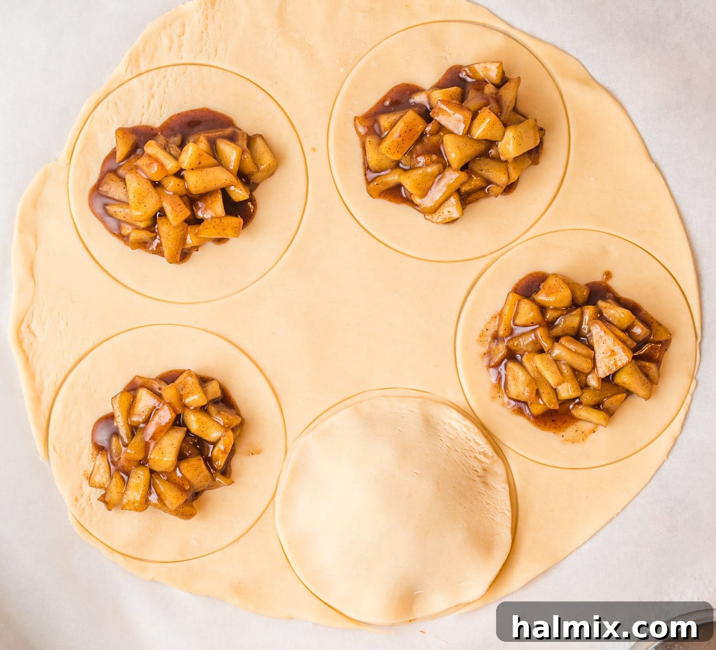 Two pie crust circles precisely pressed together to form a hand pie, demonstrating a secure seal around the filling.