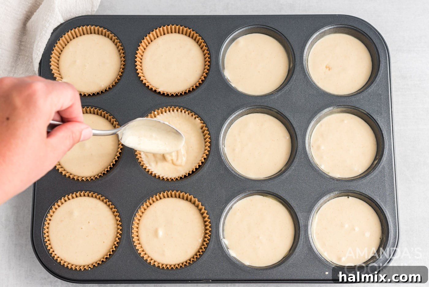 3-Ingredient Apple Pie Bites 6 A spoon scooping apple pie cupcake batter into a lined baking pan.