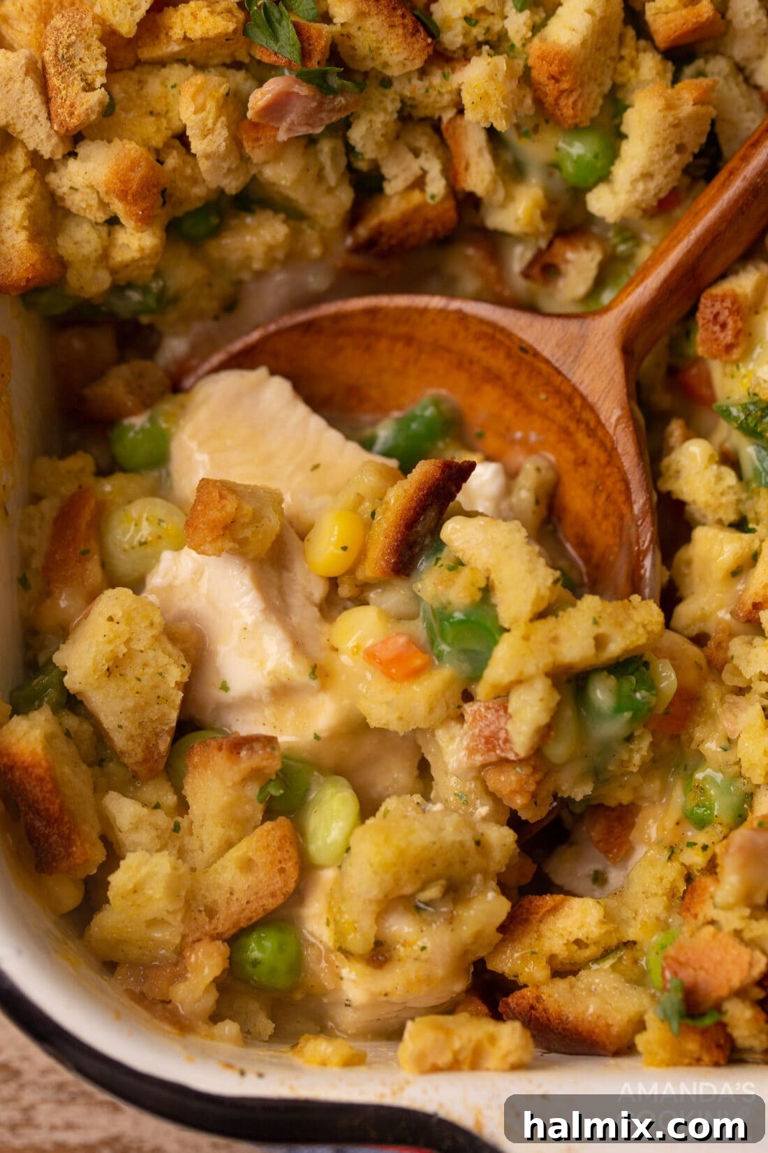 Comforting Chicken Stuffing Bake 2 wooden spoon in dish of Chicken Stuffing Casserole