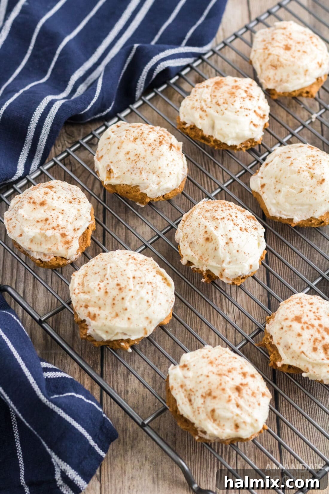 Delicious Pumpkin Cake Mix Treats 2 Freshly baked Pumpkin Cake Mix Cookies cooling on a wire rack, topped with cream cheese frosting and cinnamon