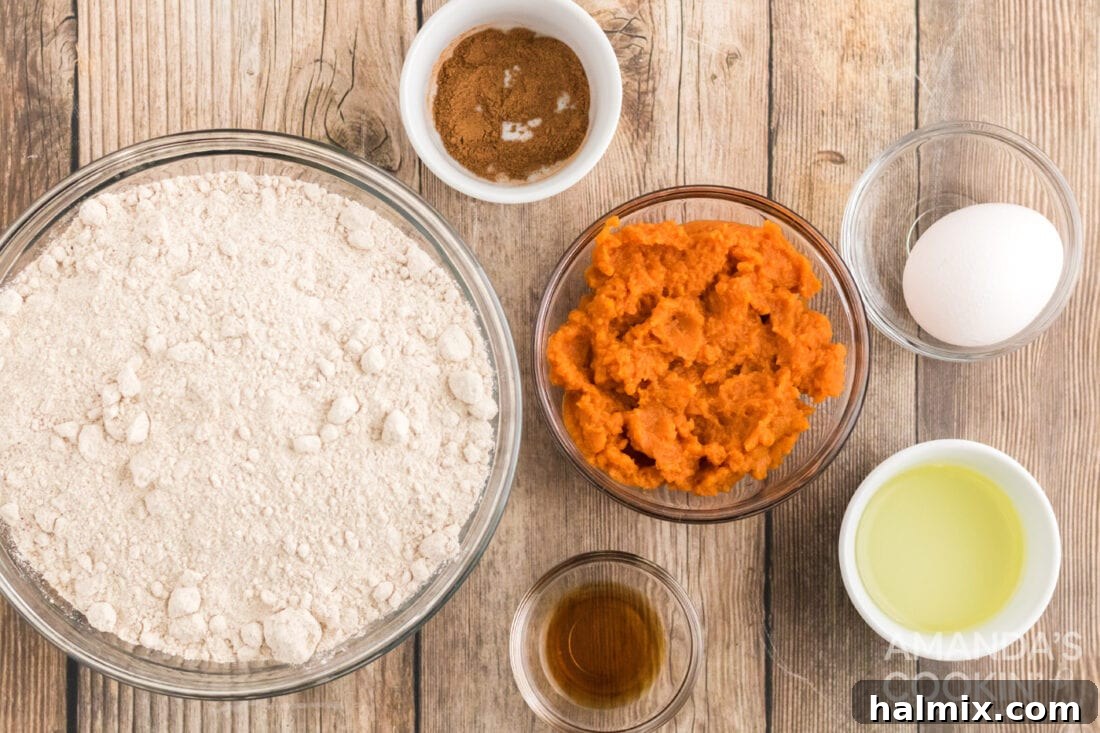 Delicious Pumpkin Cake Mix Treats 4 A selection of dry and wet ingredients laid out for making Pumpkin Cake Mix Cookies, including a box of cake mix, pumpkin puree, eggs, and spices.