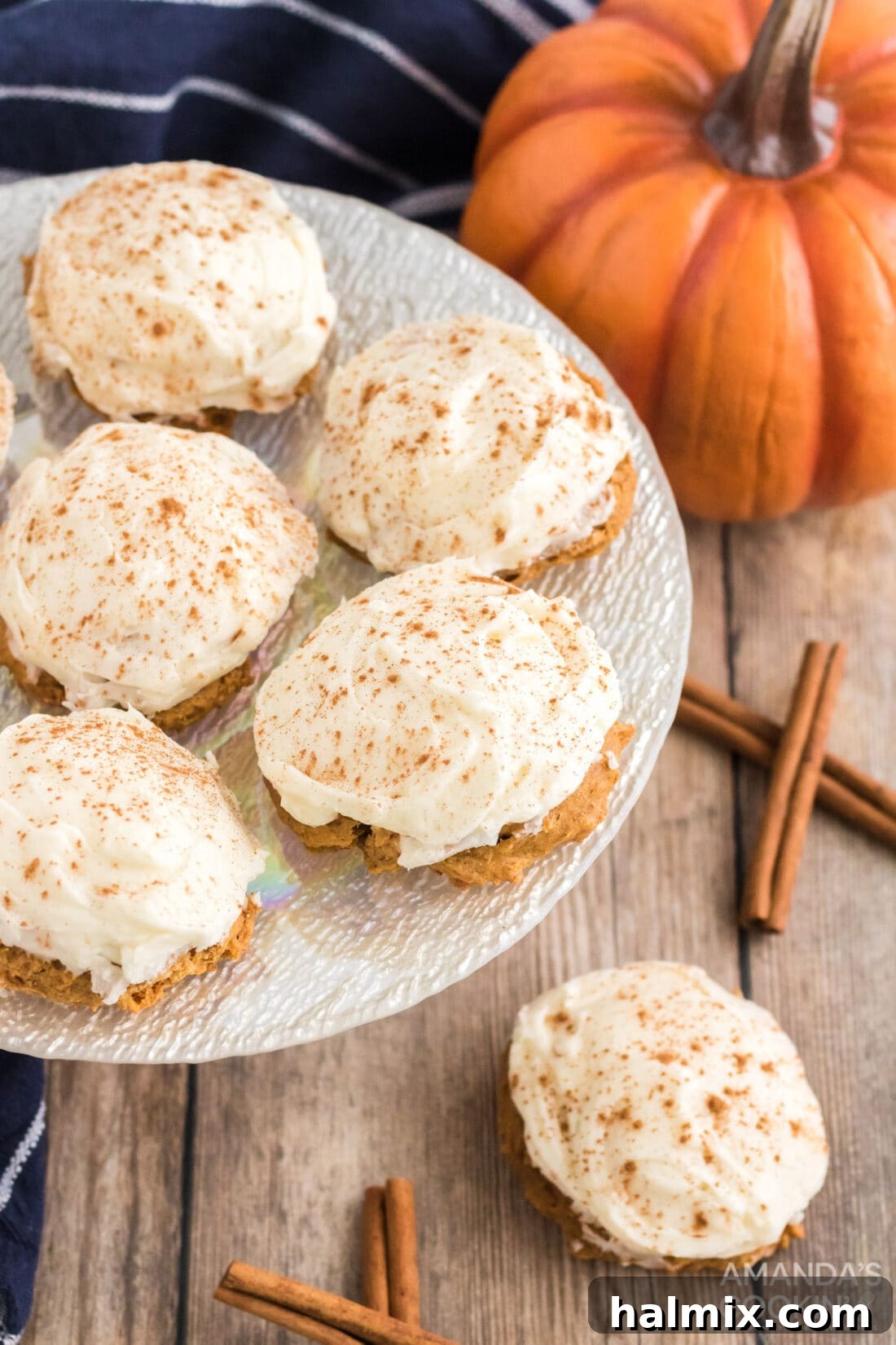 Delicious Pumpkin Cake Mix Treats 10 A beautifully arranged plate of Pumpkin Cake Mix Cookies, each perfectly frosted and garnished with cinnamon, ready to be enjoyed.