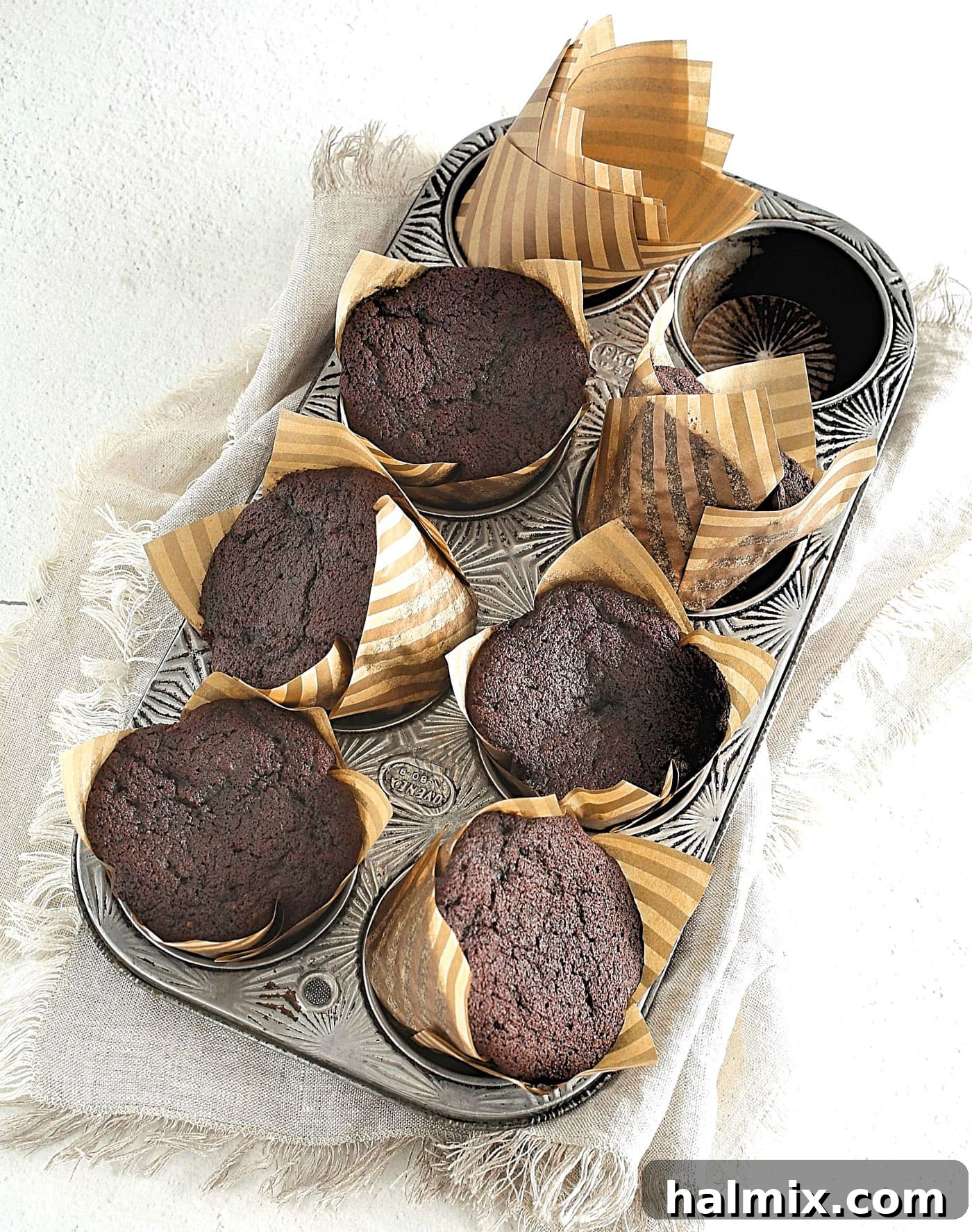 Chocolate cupcake batter in a muffin pan, ready for baking.