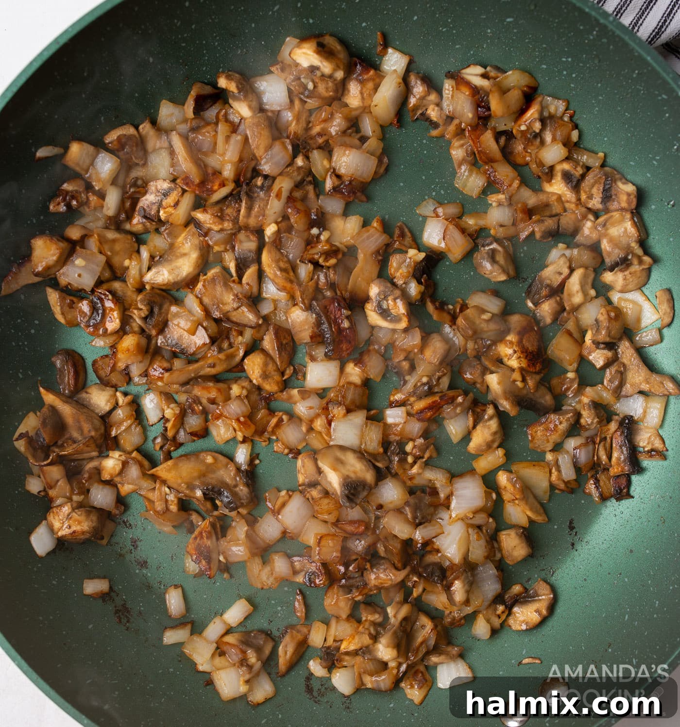 Creamy Beef Noodle Bake 6 Mushrooms and onions sautéing in a skillet with minced garlic, turning golden brown.