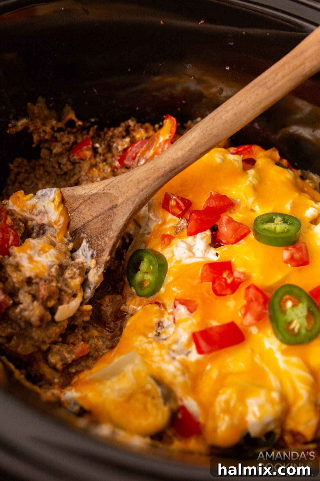 A rich and cheesy Crockpot John Wayne Casserole in a black slow cooker, ready to serve.