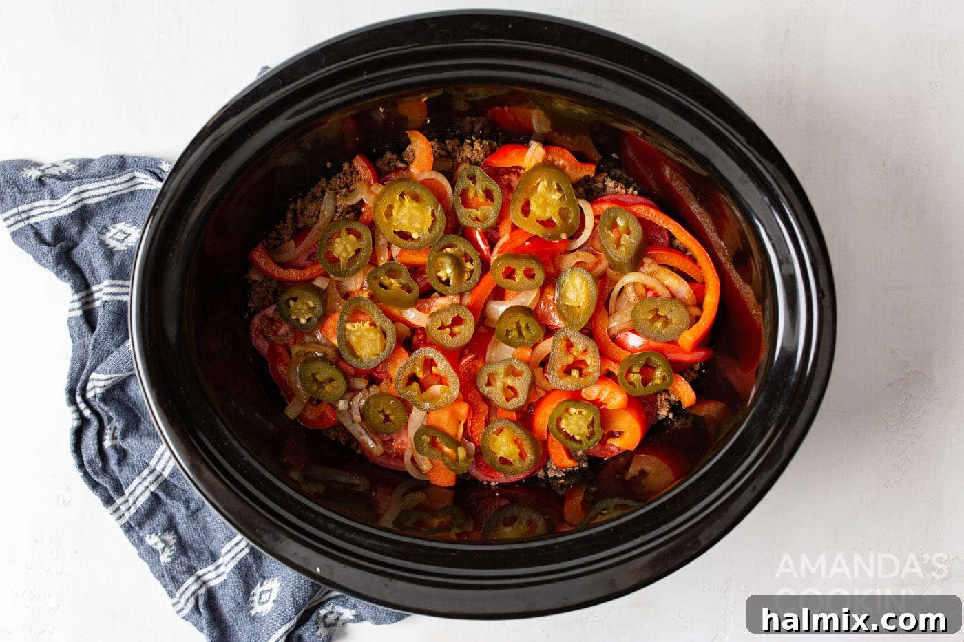 Canned jalapenos scattered over the tomato and beef layers, adding a gentle spice.