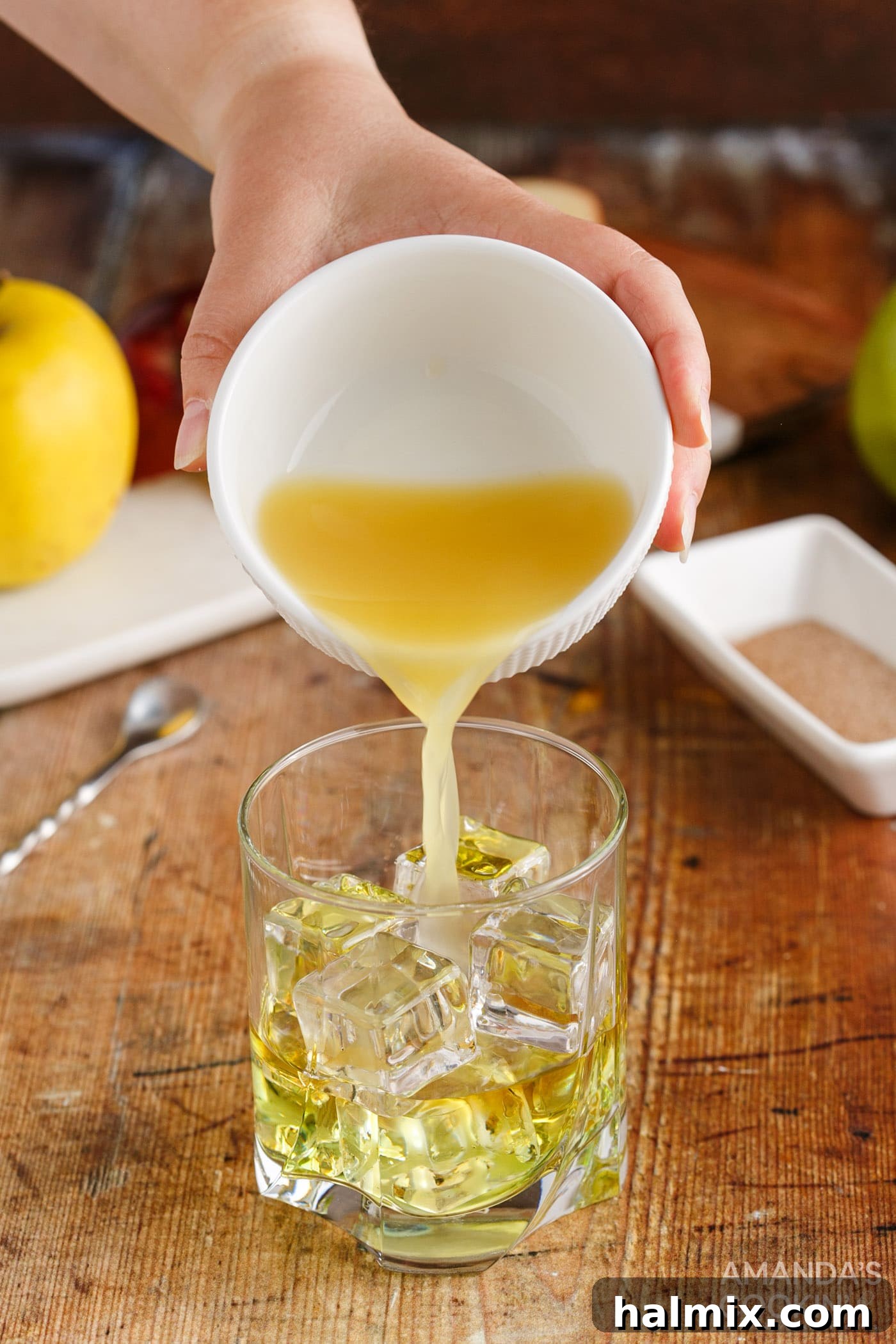 pouring pineapple juice into a rock glass