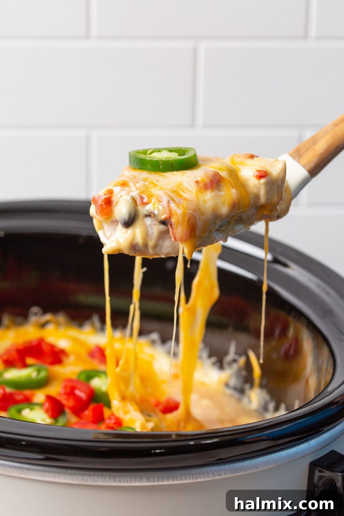 Slow Cooker Fiesta Chicken 3 spoon lifting mexican chicken from crockpot