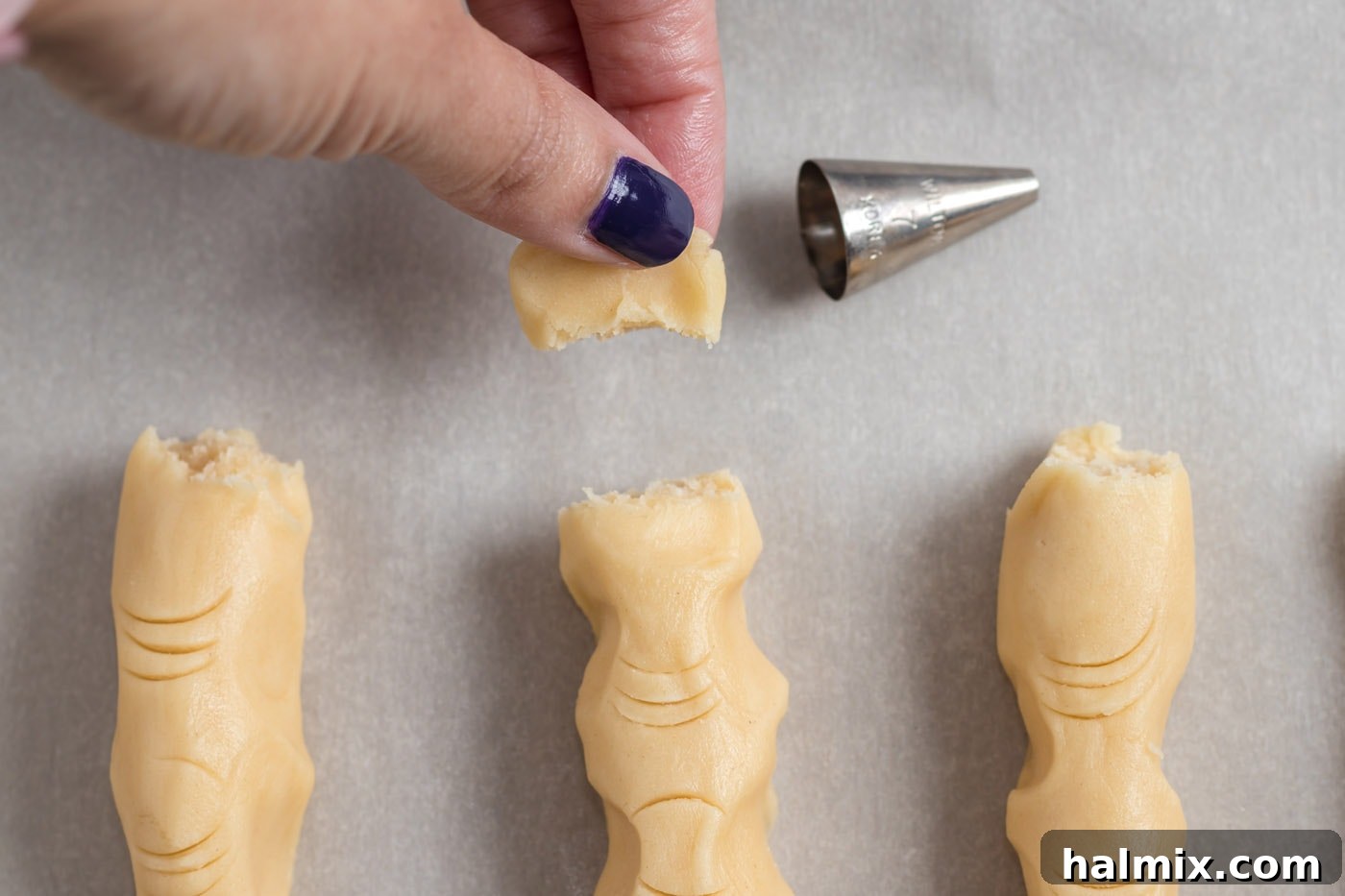 Hexed Hand Delights 13 A small portion of the cookie dough finger's end has been broken off to simulate a severed look, adding to its grotesque appeal.