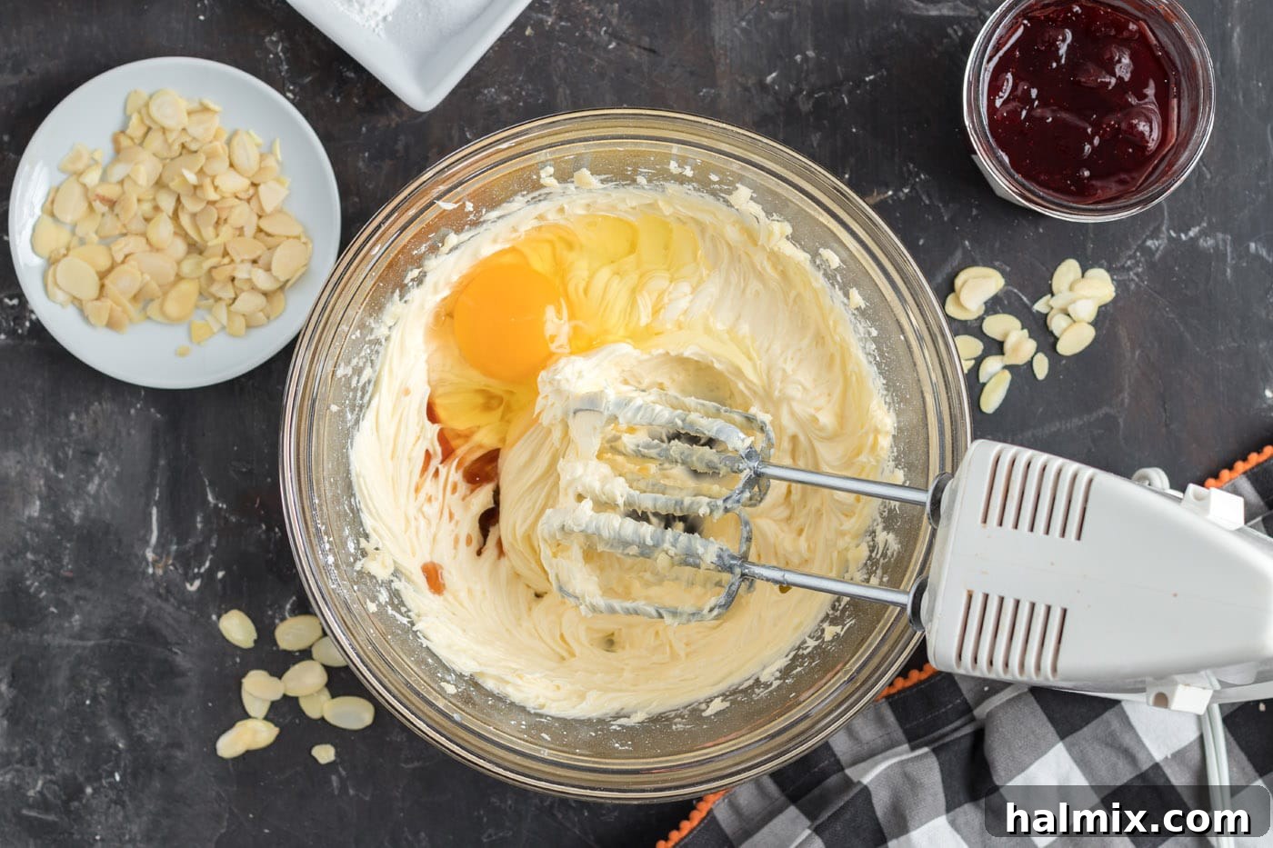 Hexed Hand Delights 6 Egg and vanilla extract have been mixed into the creamed butter and powdered sugar, creating a smooth, pale yellow batter.