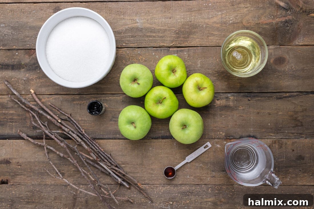 A collection of ingredients laid out on a table, including green apples, sugar, corn syrup, and food coloring, ready for making Halloween candy apples.
