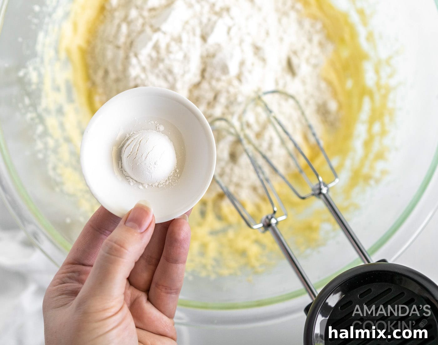 Pound Cake Minis 7 Adding baking powder to a bowl over pound cake mix