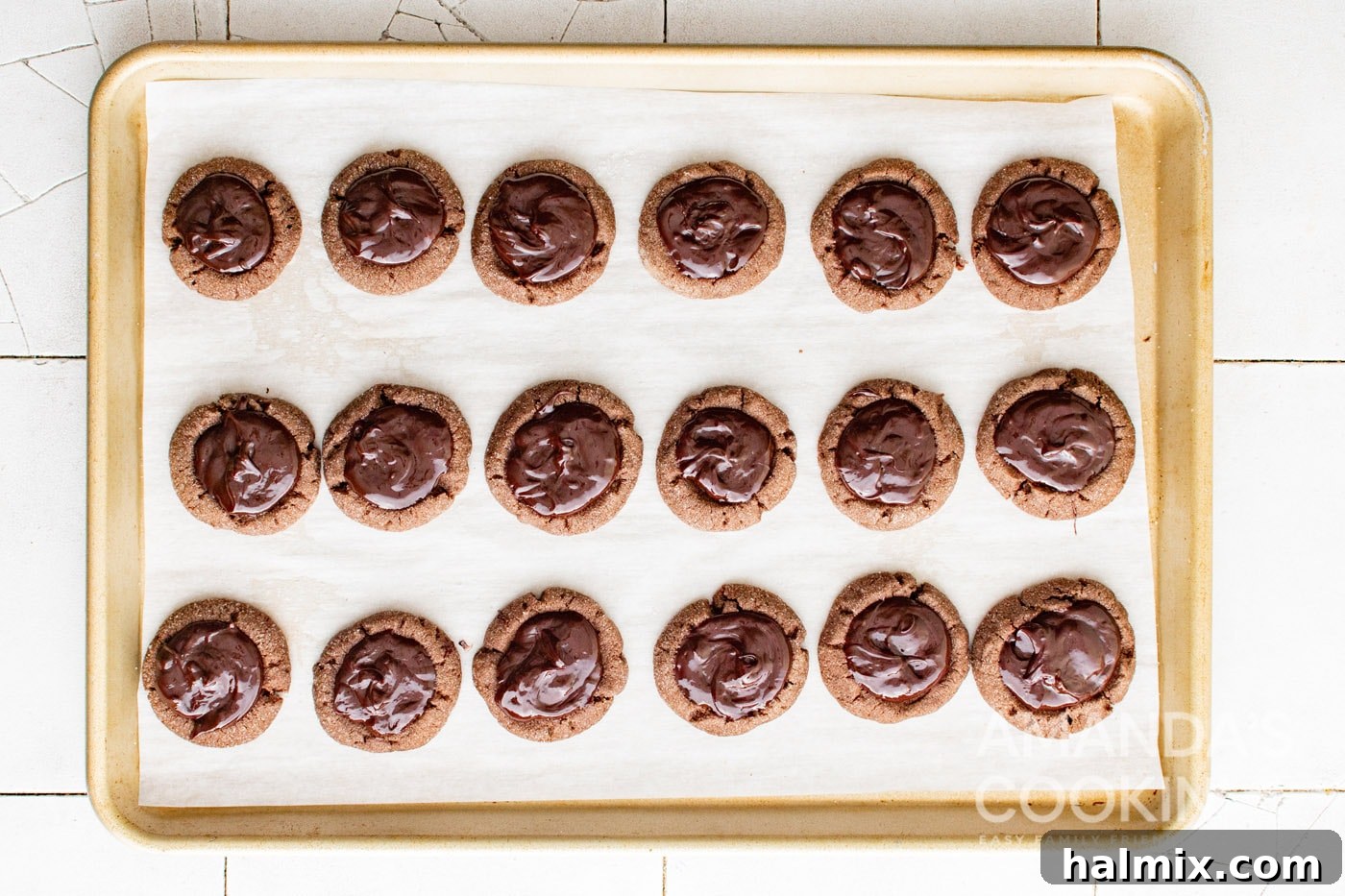 chocolate filled thumbprint cookies on a wire rack.