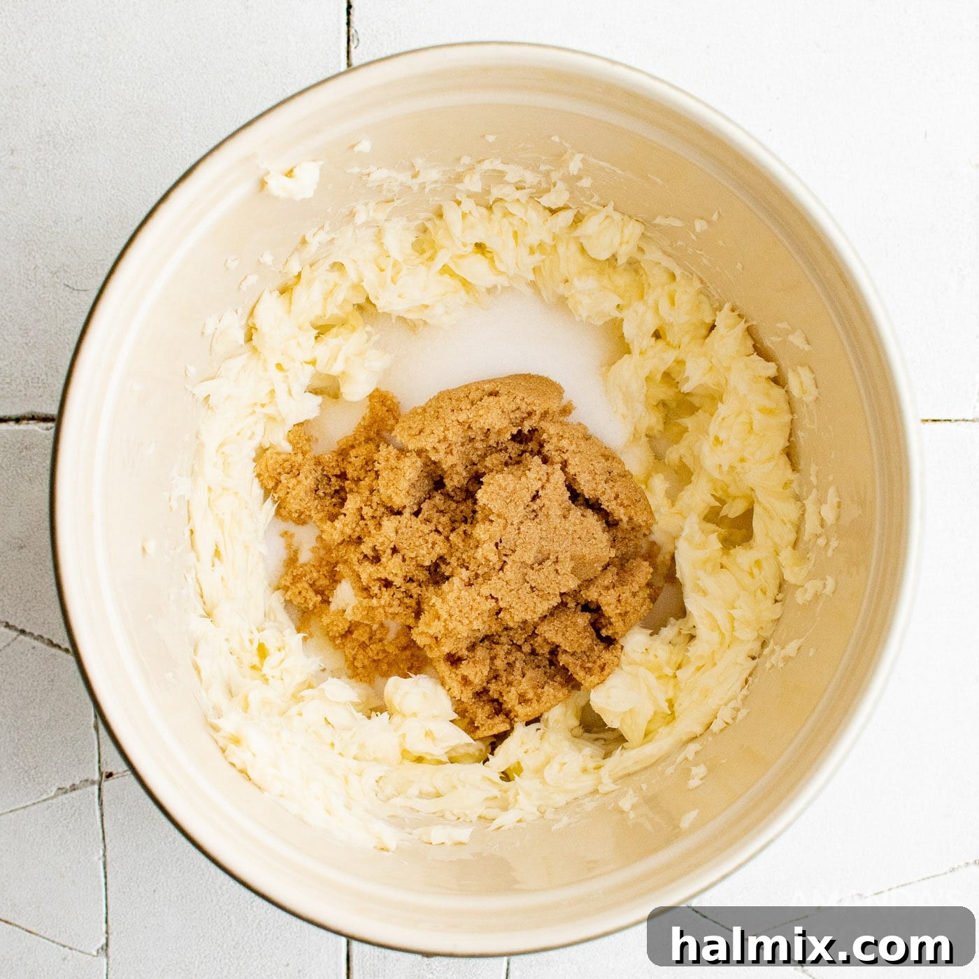 brown sugar, butter, and granulated sugar in mixing bowl being creamed together.