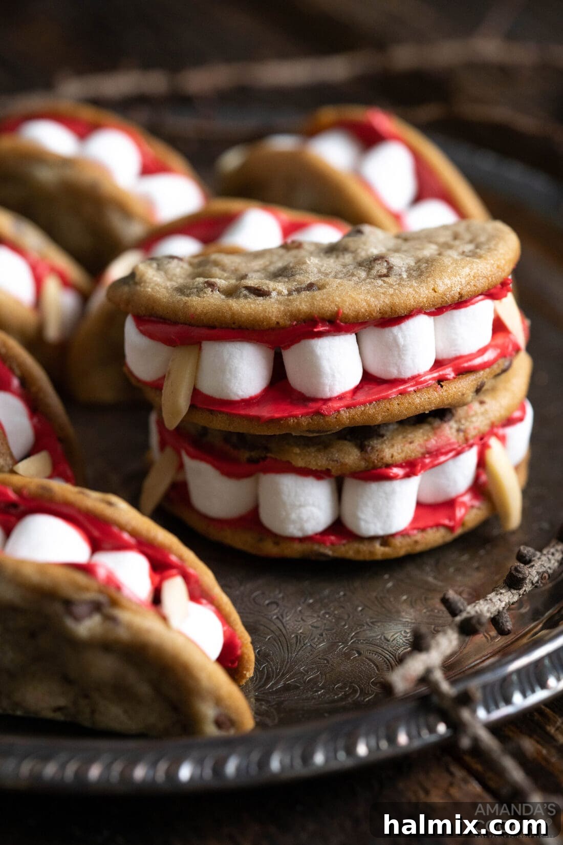 Vampire Sandwich Cookies on a plate, showcasing their spooky and fun design with red frosting, marshmallow teeth, and almond fangs.