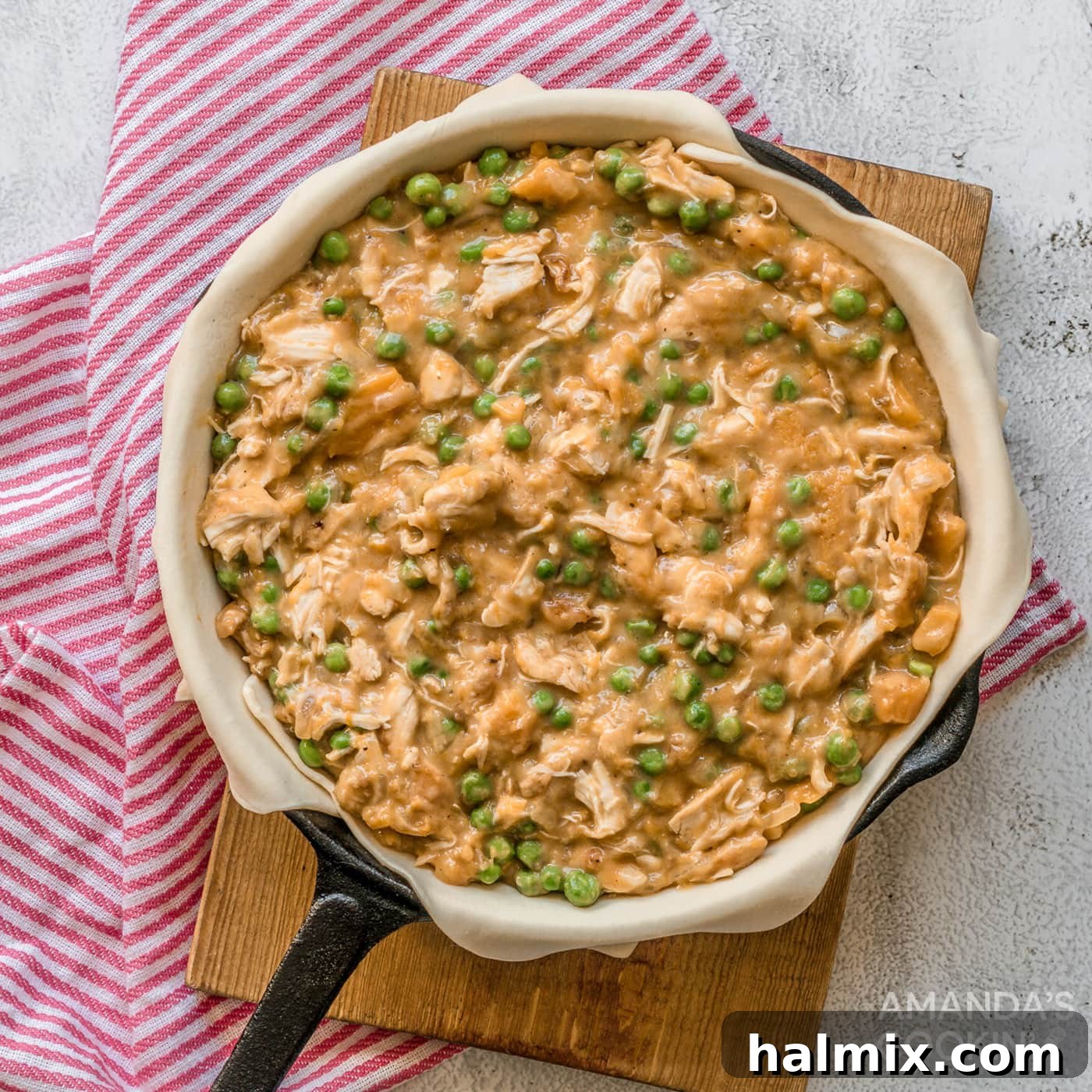 The vibrant pumpkin chicken filling nestled invitingly within the puff pastry-lined skillet, ready for its topping