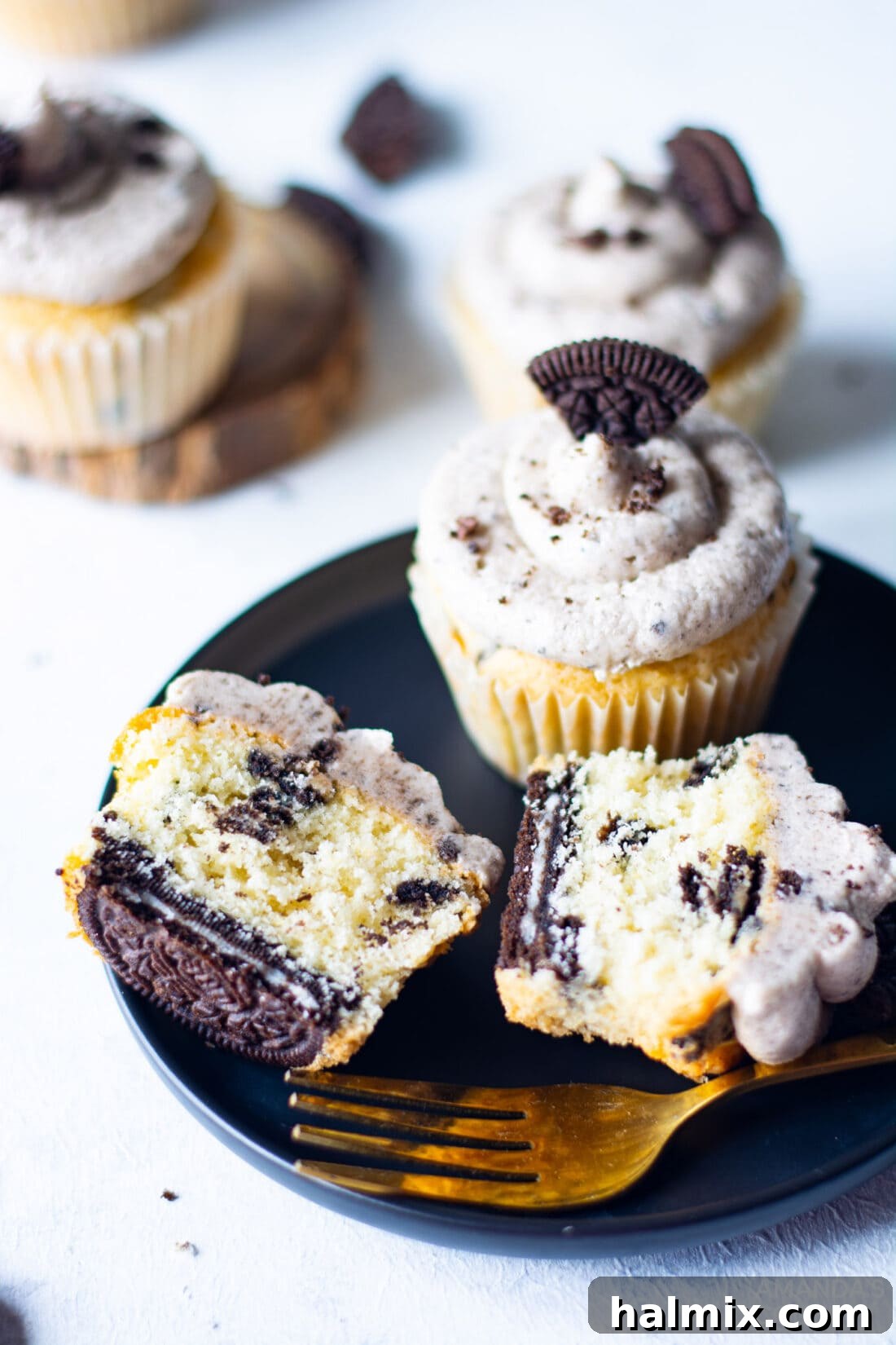 A selection of delicious Oreo Cupcakes, some whole and some cut in half to showcase the inner cookie layers, arranged beautifully on a serving plate.