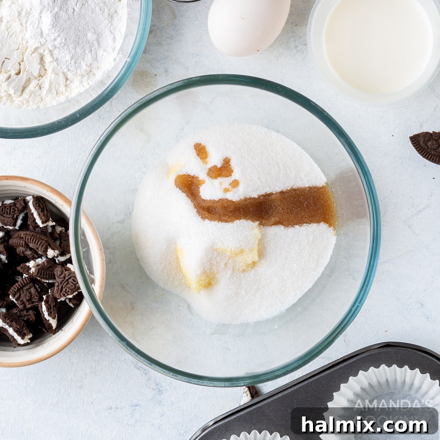 Room temperature butter, granulated sugar, and vanilla extract are being creamed together in a mixing bowl with an electric mixer.