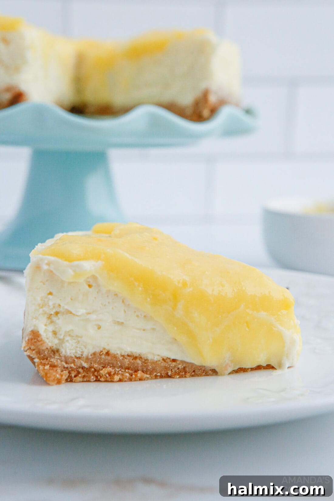 Slice of creamy Instant Pot Lemon Curd Cheesecake with a generous layer of vibrant lemon curd, ready to be enjoyed.