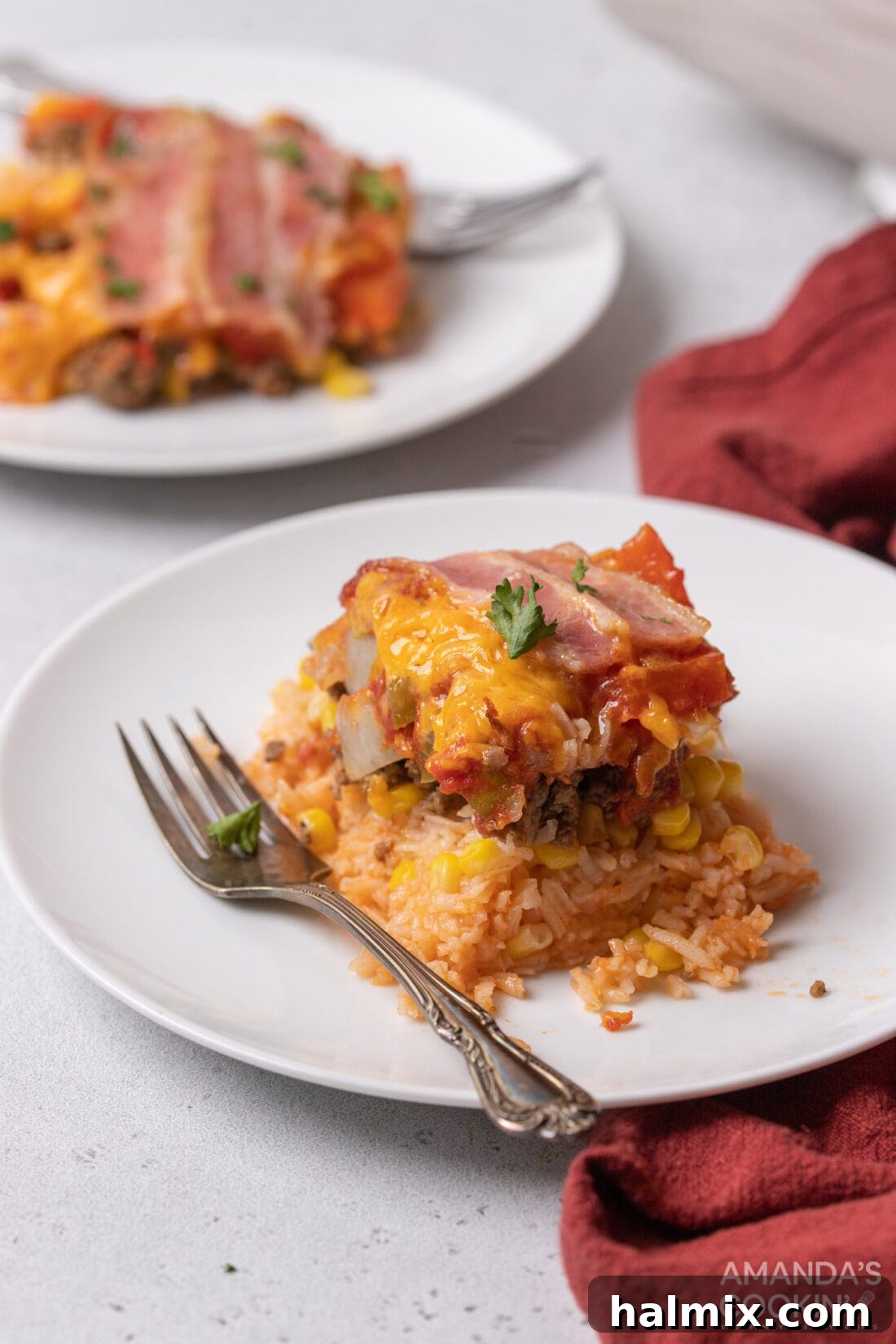 Individual slice of 7 Layer Casserole on a white plate, garnished with parsley