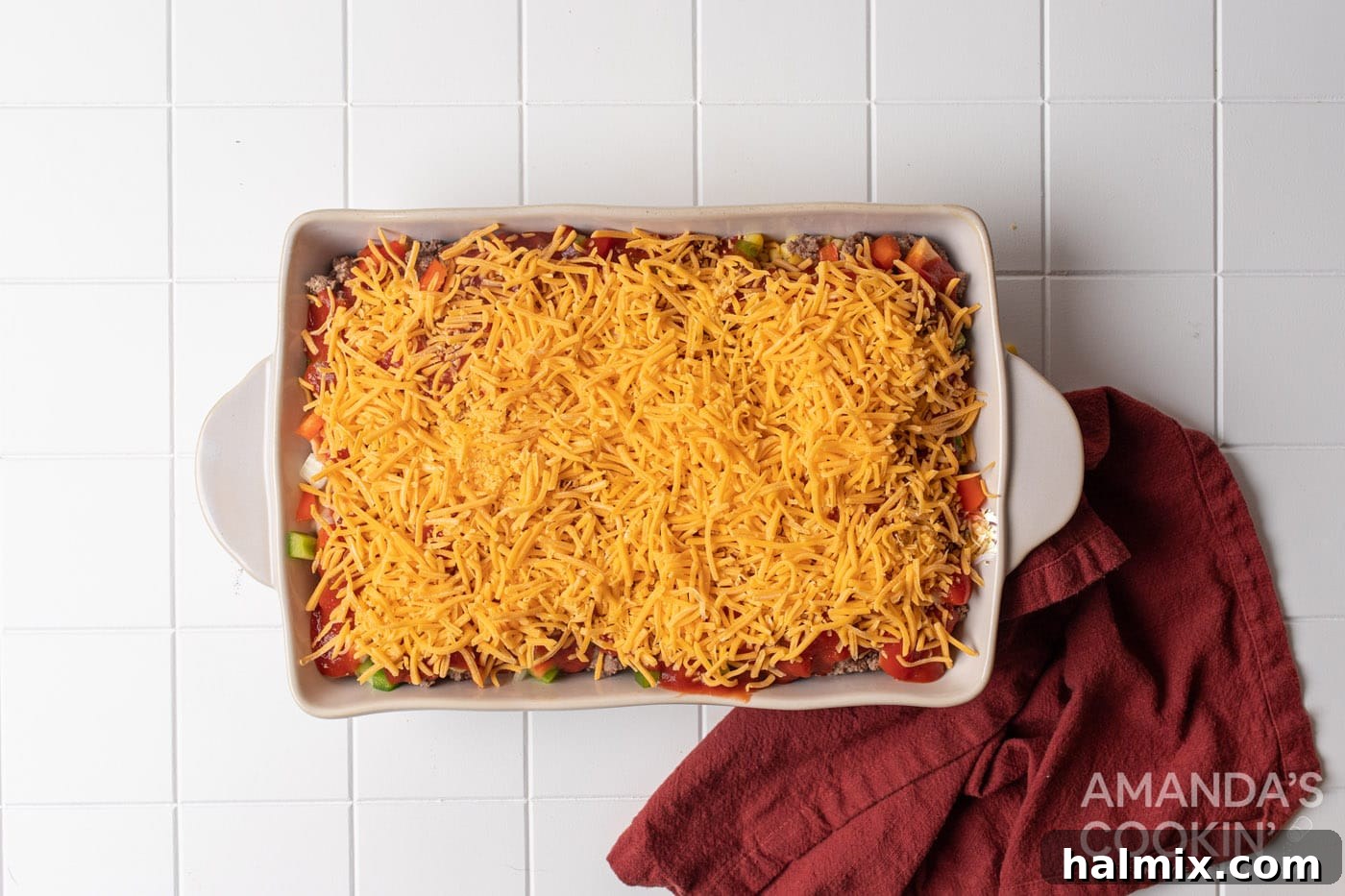 shredded cheese is sprinkled generously on top of the casserole