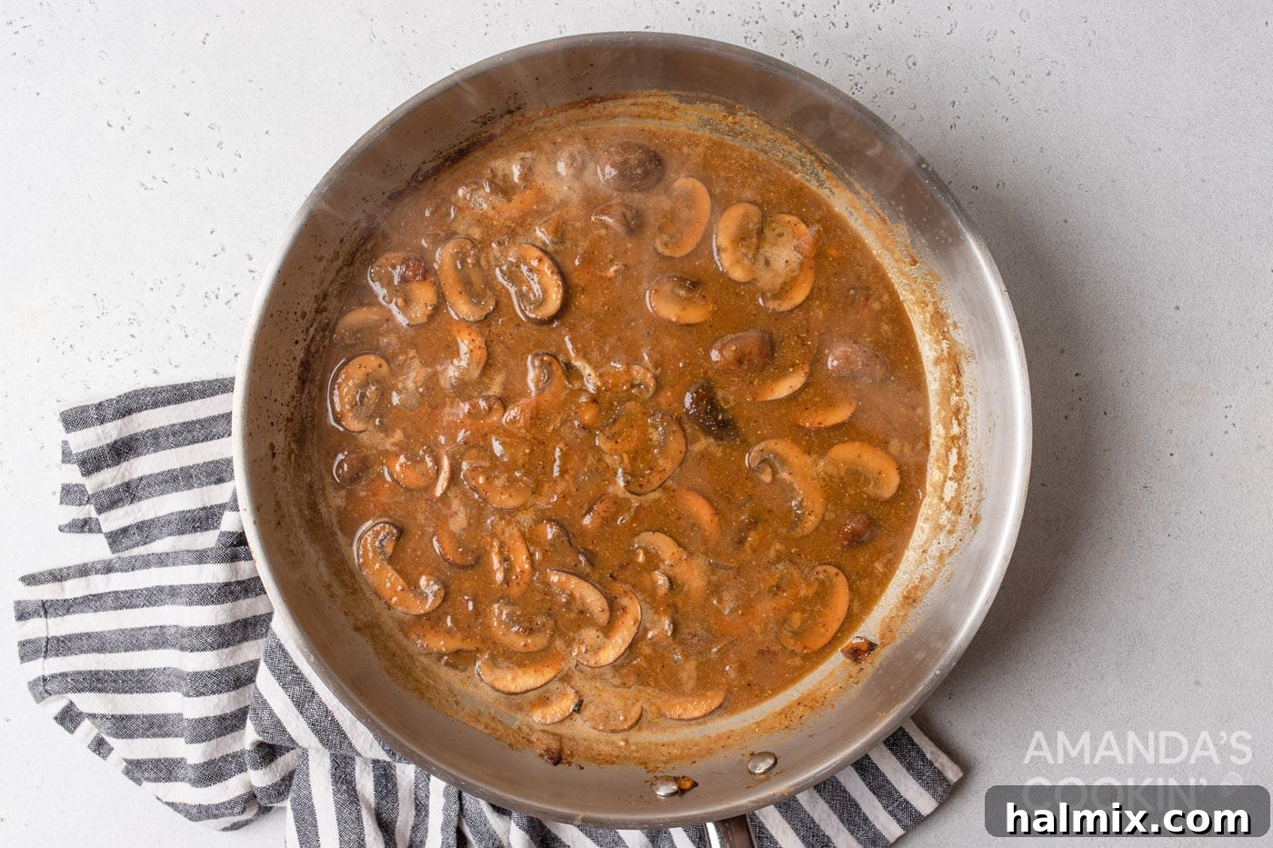 chicken stock added to skillet of mushrooms and onions