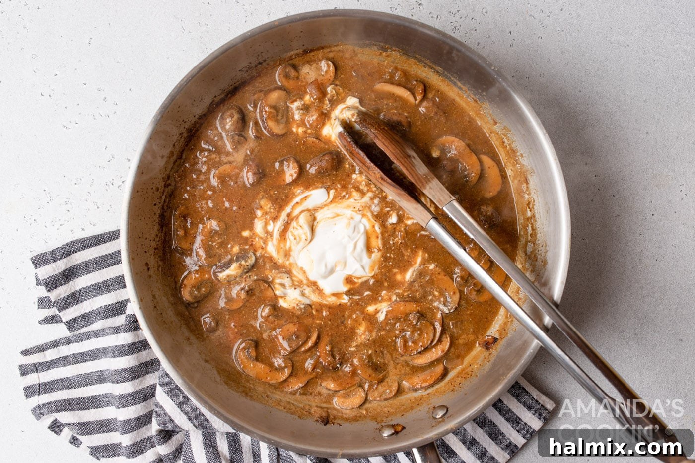stirring sour cream into stroganoff sauce
