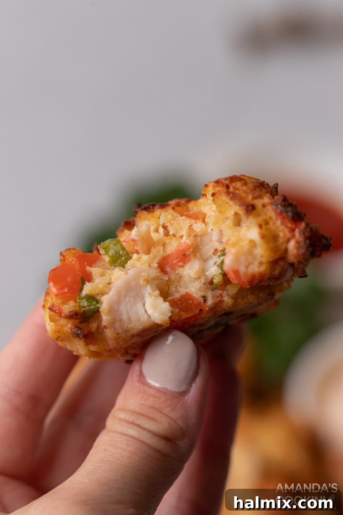 holding an Air Fryer Crab Cake with a bite out of it