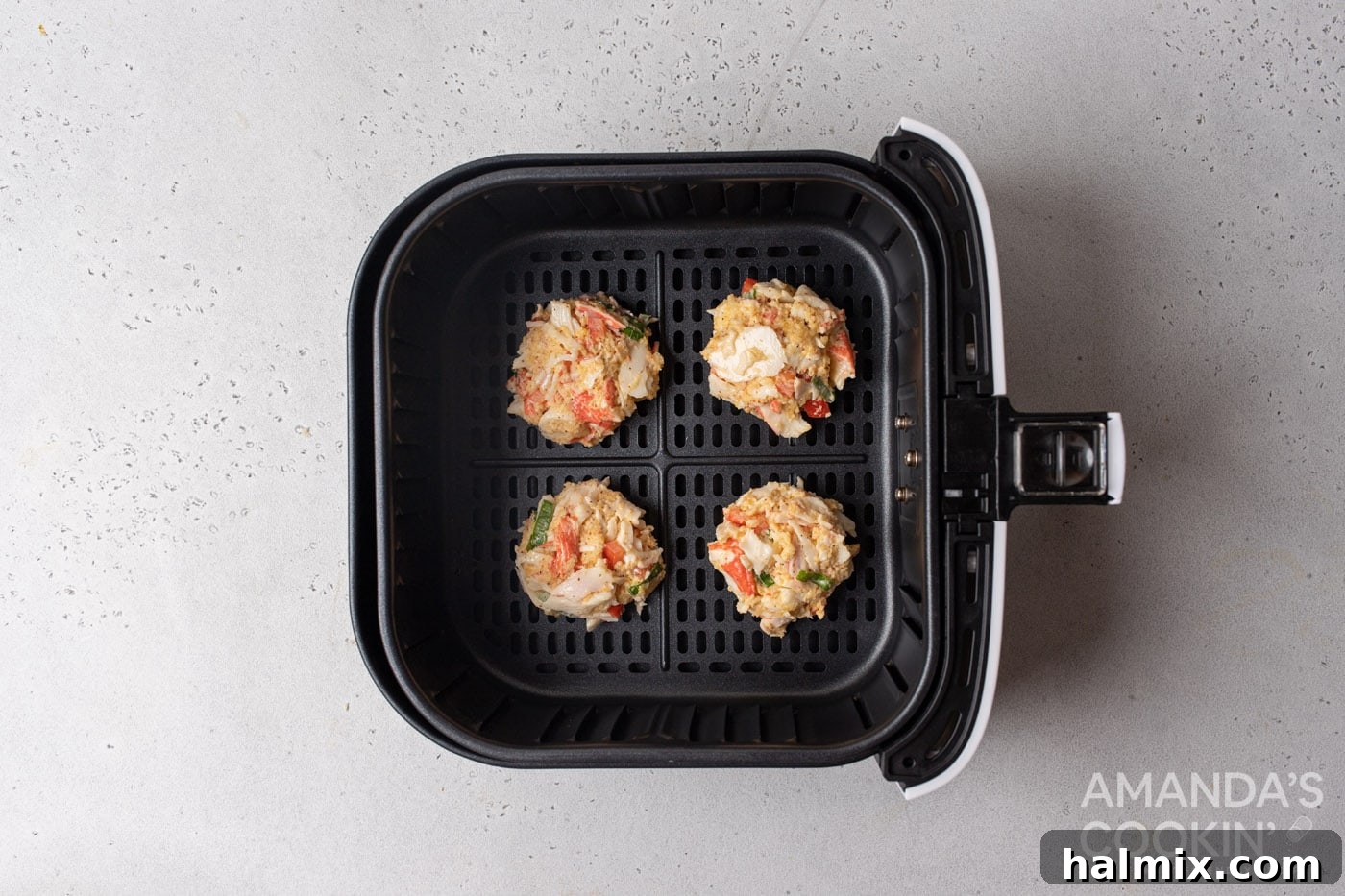 crab cake patties in an air fryer basket