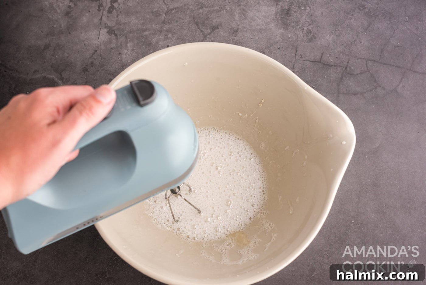 mixing gelatin and sugar water in a bow with hand mixer