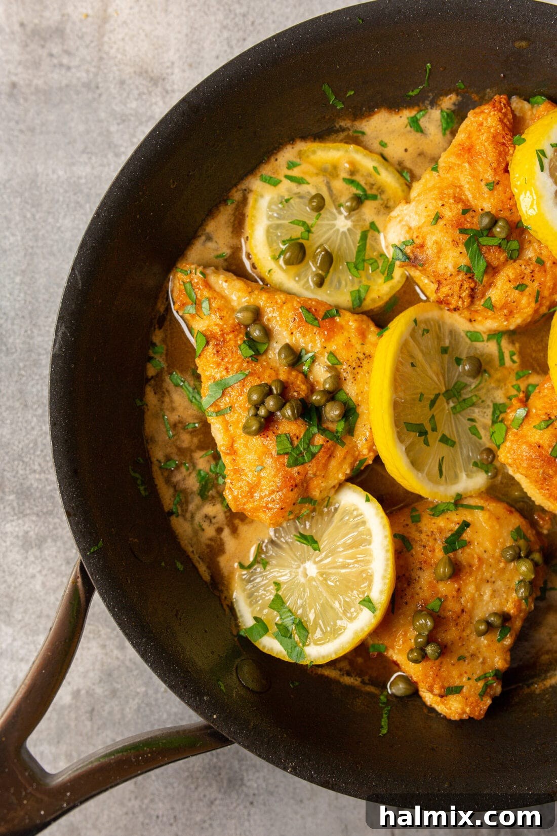 Zesty Lemon Caper Chicken 2 Pan of golden-brown Chicken Piccata with lemon slices and capers