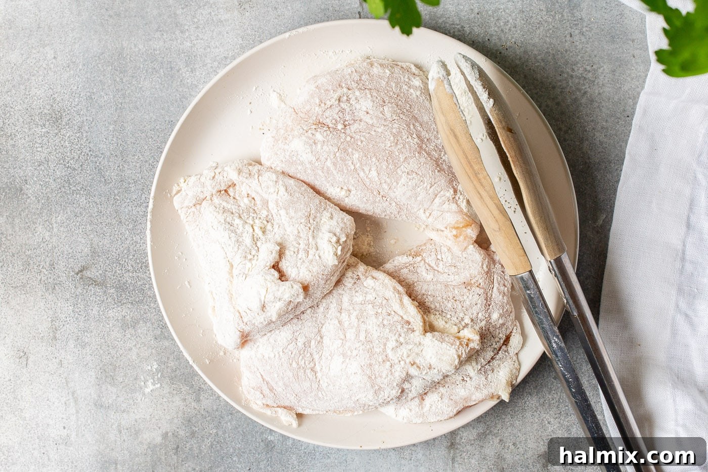 Zesty Lemon Caper Chicken 5 Flour-coated chicken breasts ready for pan-frying